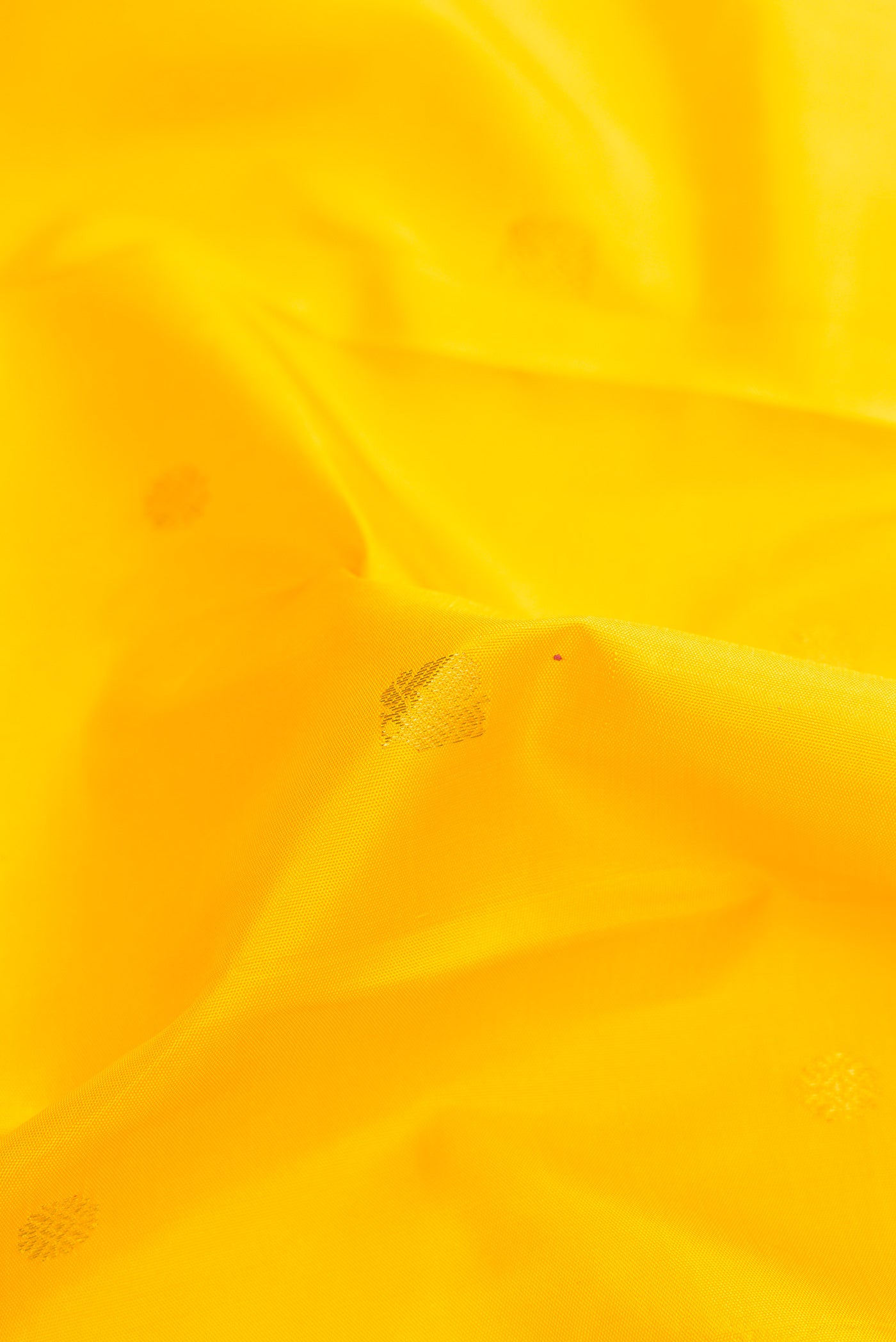 Close up of Pure Silk Pure Zari Yellow Dual Tone Kanjivaram Saree with Zari Butta on the body and Zari Border.  displaying folds