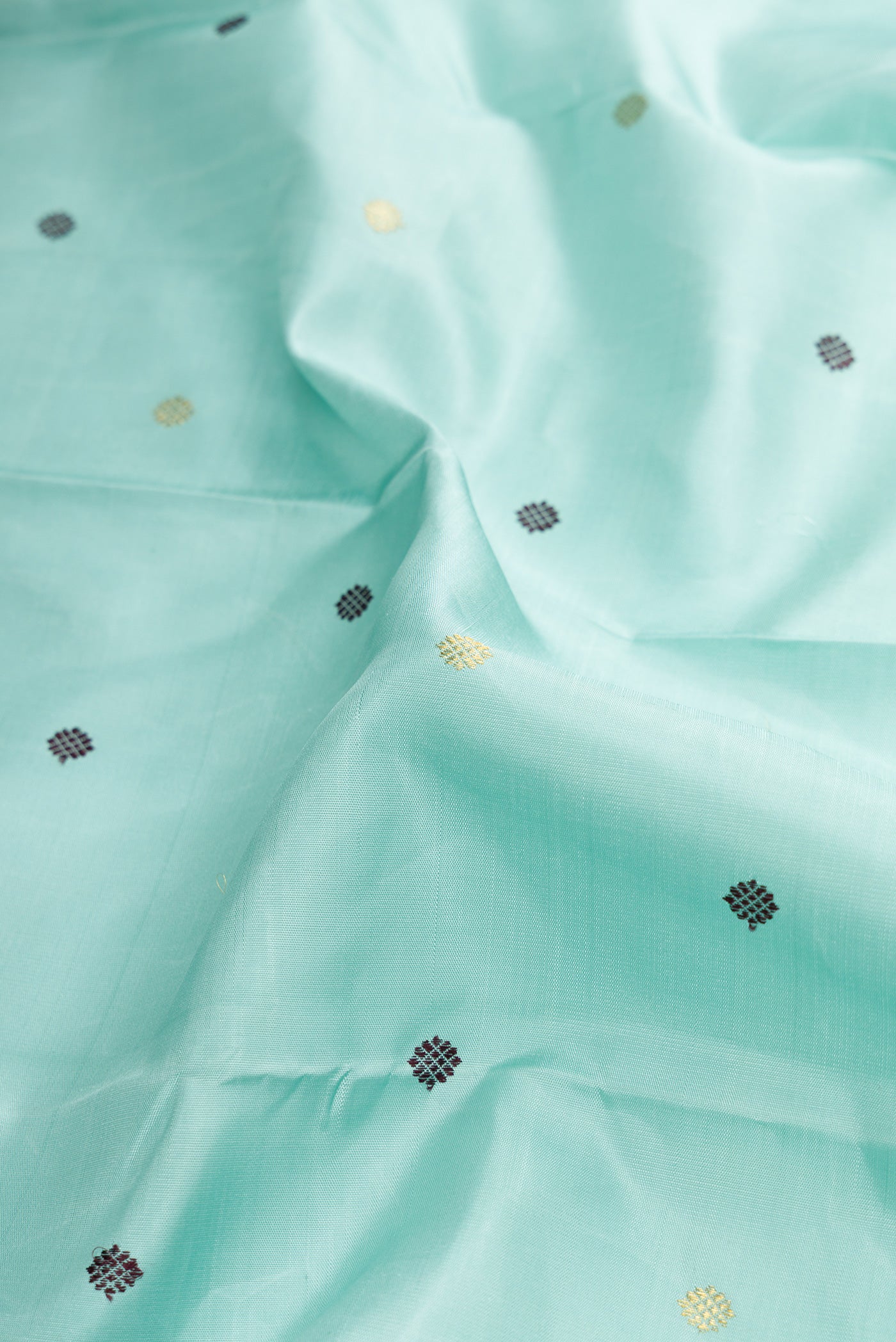 Close up of Sky Blue Dual Tone Kanjivaram Silk Saree with Zari And Thread Butta on the body and Zari Border.  displaying folds