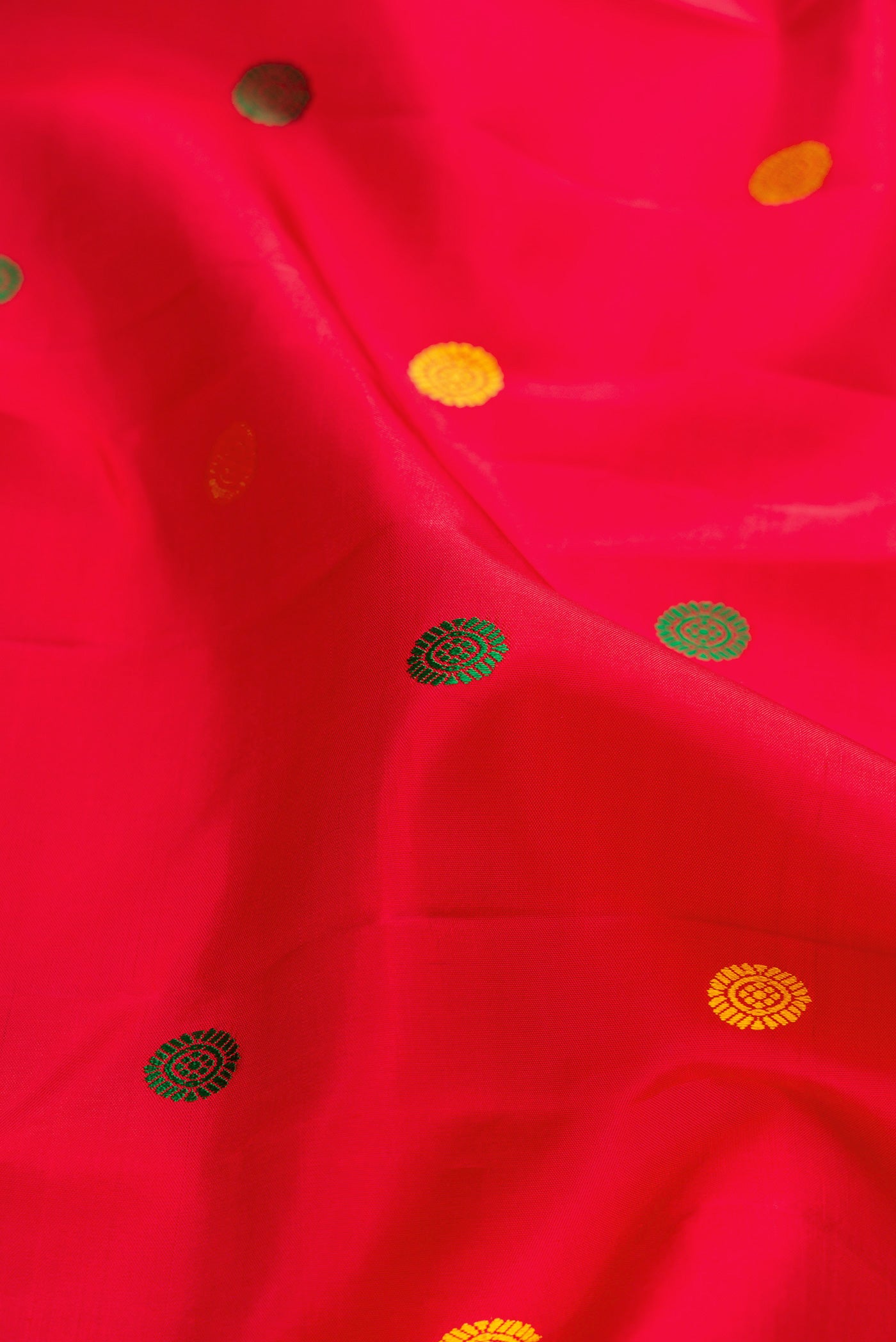 Close up of Pure Silk Pure Zari Deep Red Dual Tone Kanjivaram Saree with Thread Butta on the body and Zari Border.  displaying folds