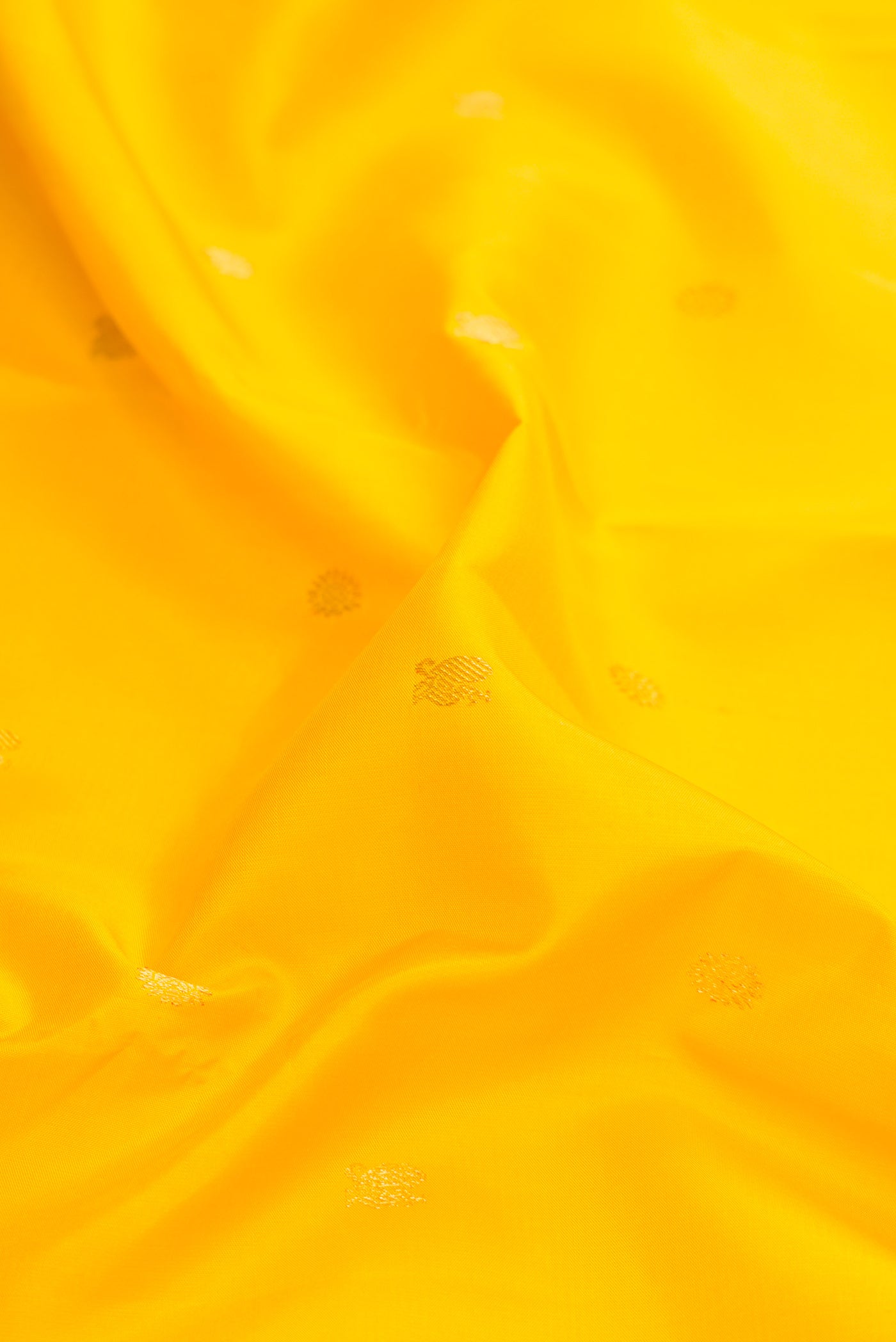 Close up of Yellow Dual Tone Kanjivaram Silk Saree with Zari Butta on the body and Ganga Jamuna Border.  displaying folds