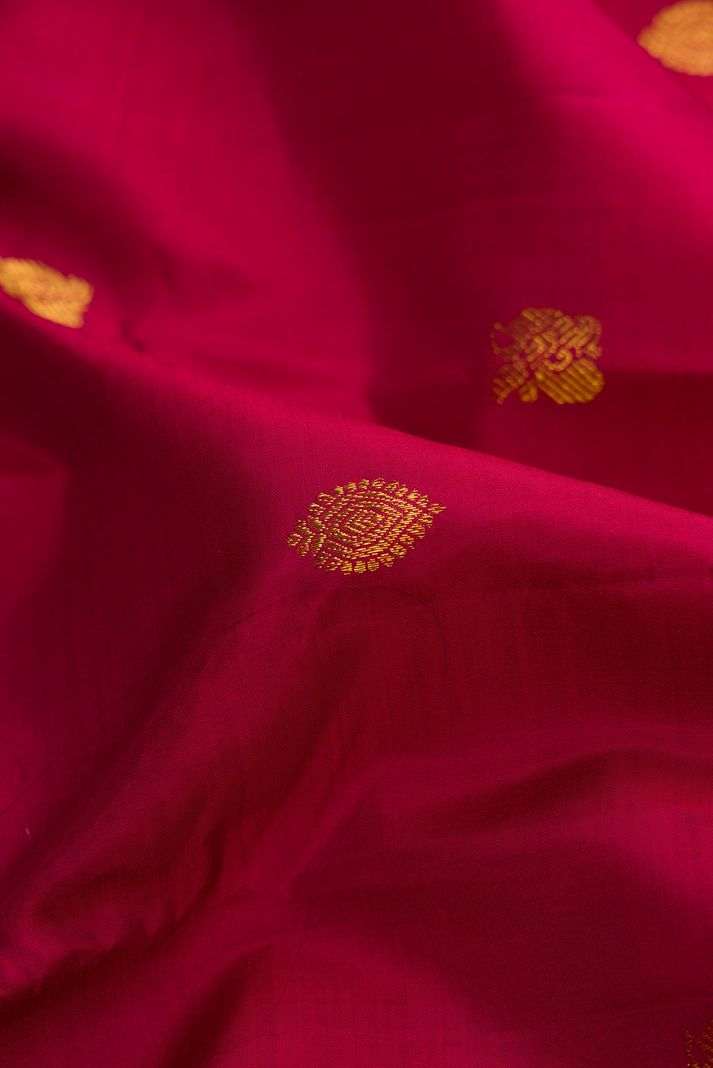 Close up of Pure Silk Pure Zari Maroon Dual Tone Kanjivaram Saree with Zari Butta on the body and Zari Border.  displaying folds