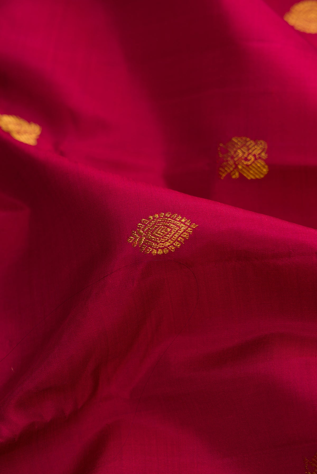 Close up of Pure Silk Pure Zari Maroon Dual Tone Kanjivaram Saree with Zari Butta on the body and Zari Border.  displaying folds