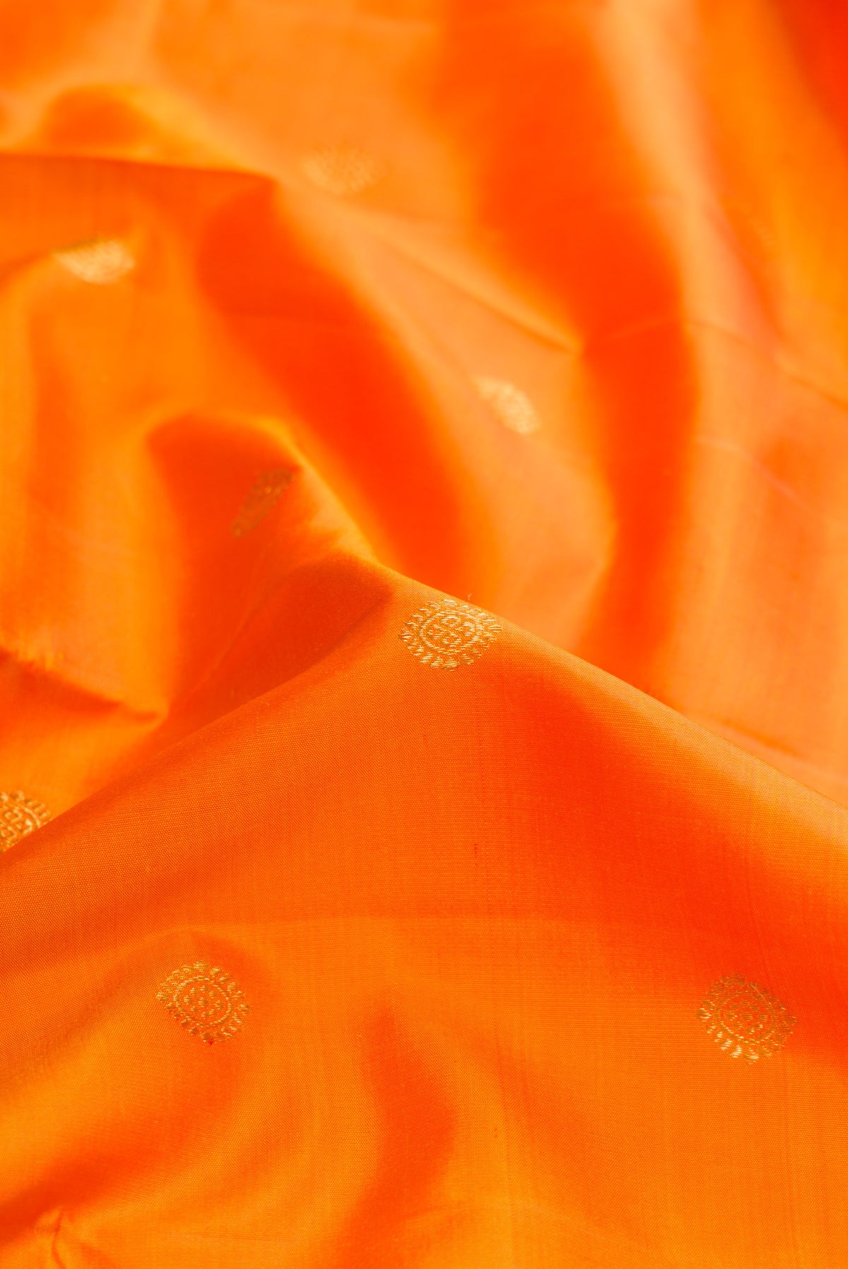 Close up of Mustard Dual Tone Kanjivaram Silk Saree with Zari Butta on the body and Zari Border.  displaying folds