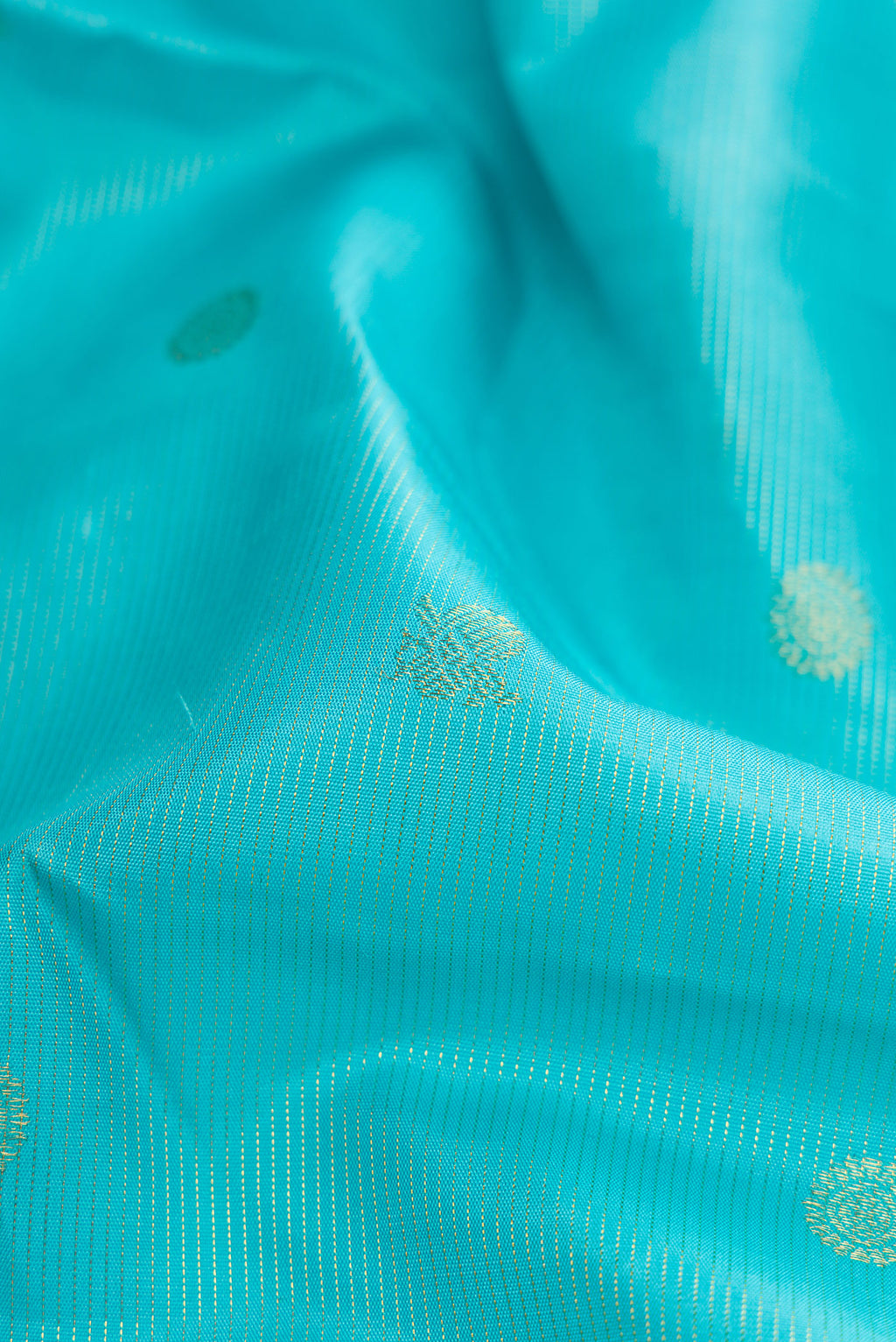 Close up of Sky Blue Dual Tone Kanchipuram Silk Saree with Zari Butta on the body and Zari And Thread Border.  displaying folds