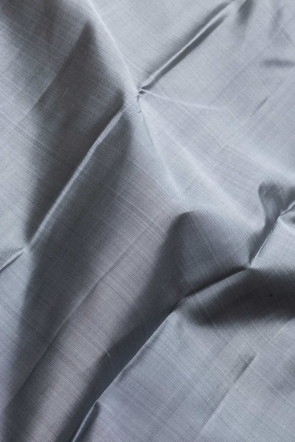 Close up of Grey Dual Tone Kanjivaram Silk Saree with Plain Body and Zari Border.  displaying folds