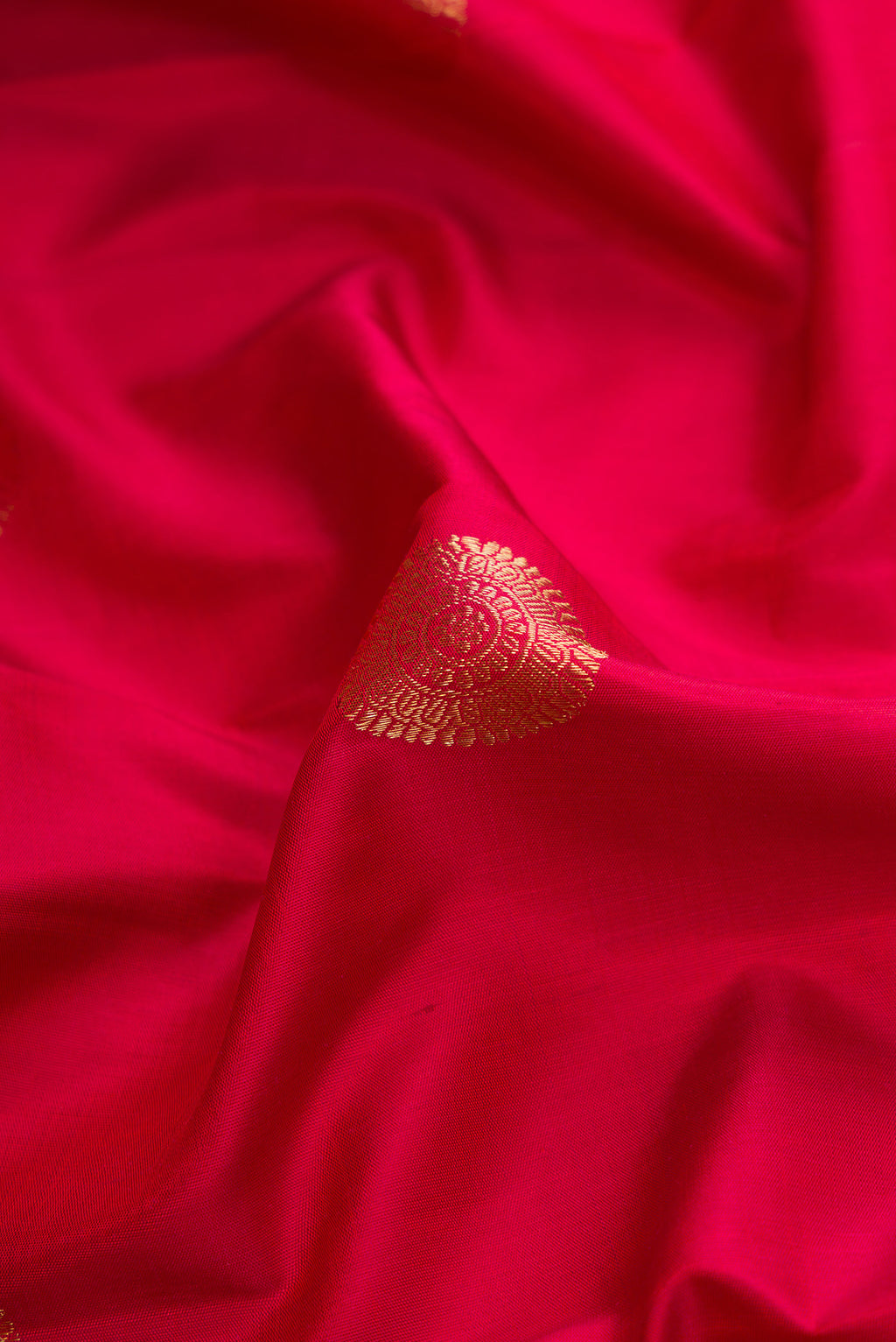 Close up of Maroon Dual Tone Kanjivaram Silk Saree with Zari Butta on the body and Zari Border.  displaying folds