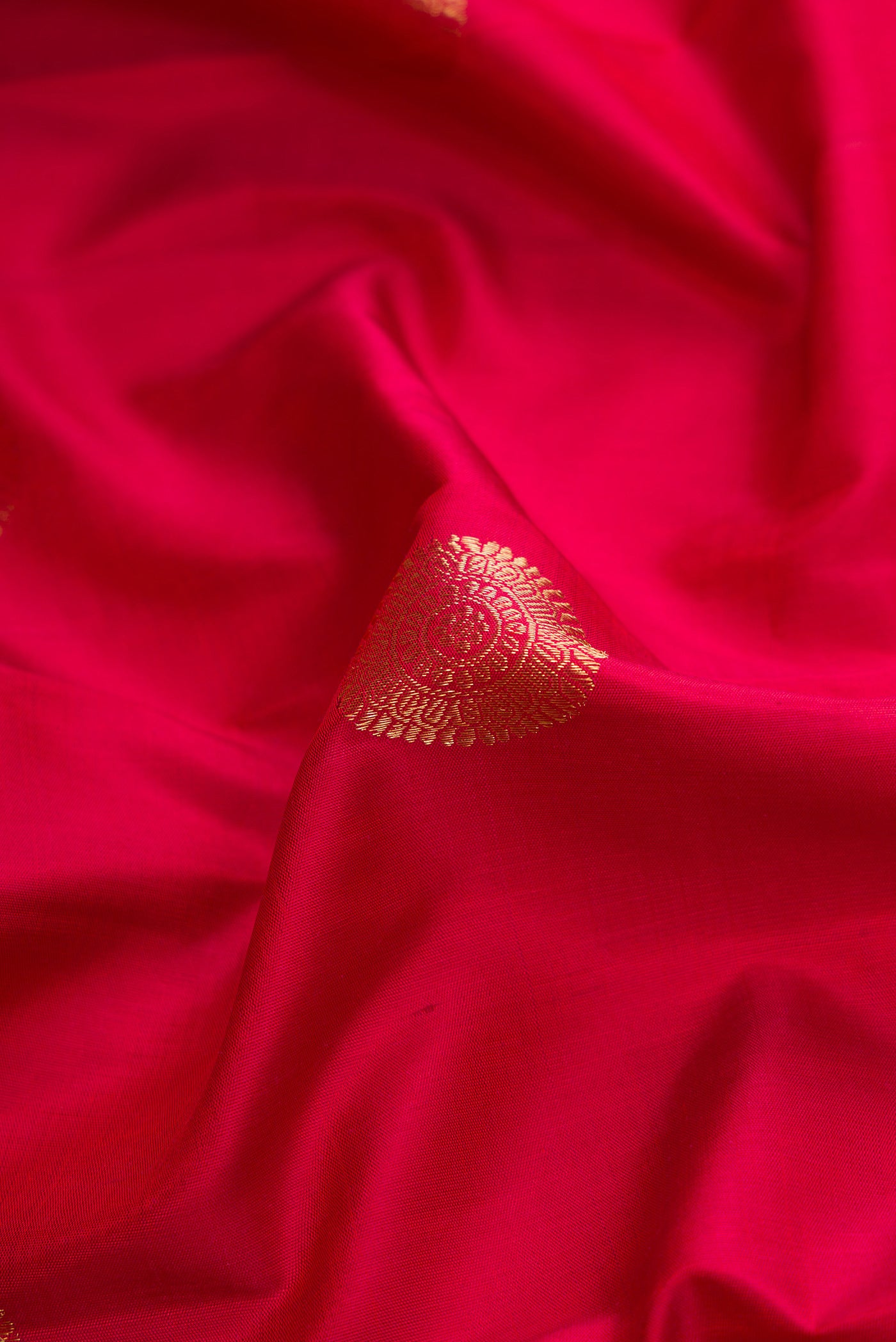 Close up of Maroon Dual Tone Kanjivaram Silk Saree with Zari Butta on the body and Zari Border.  displaying folds