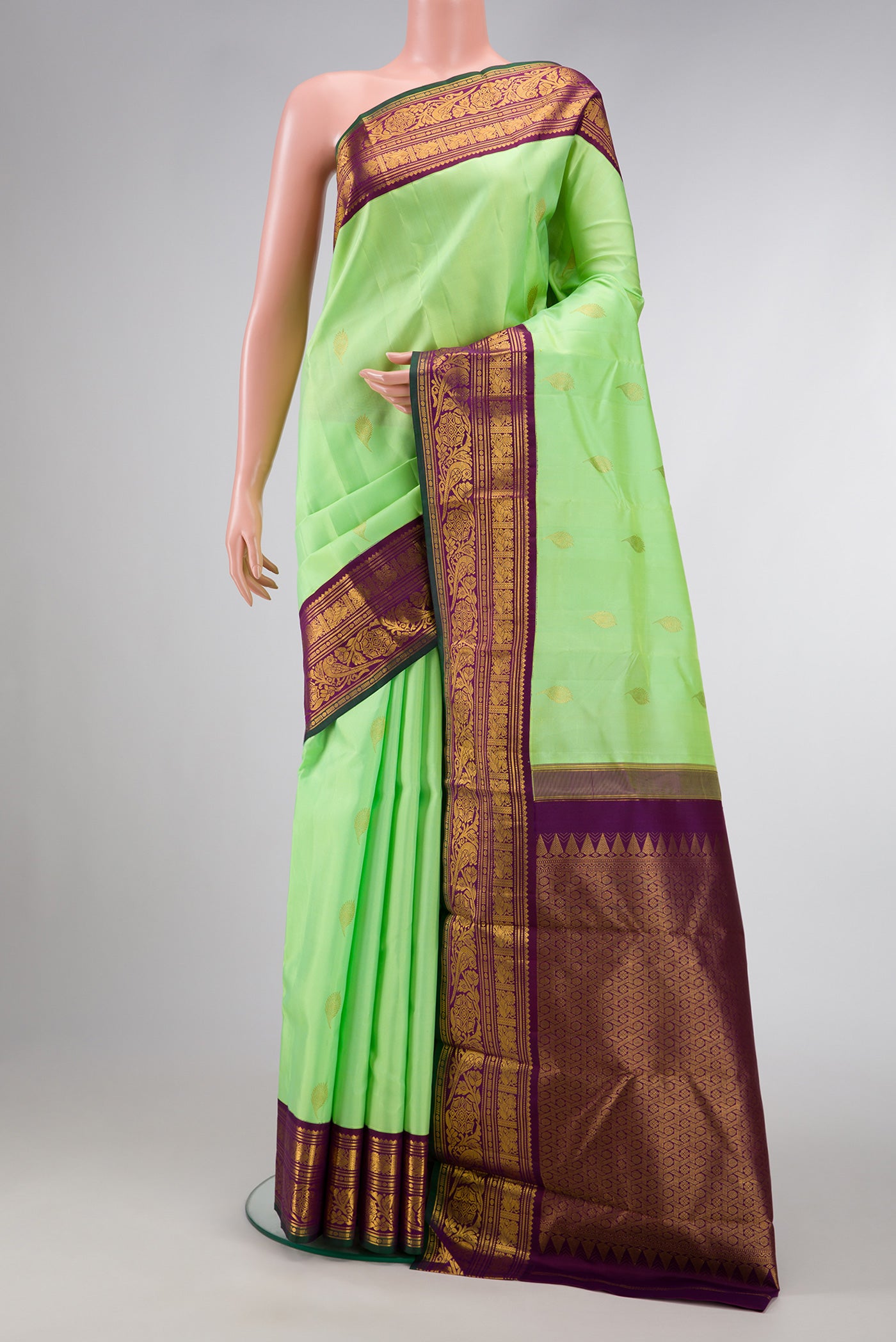 Parrot Green Dual Tone Kanjivaram Silk Saree with Zari Butta on the body and Zari Border.  displayed on a mannequin