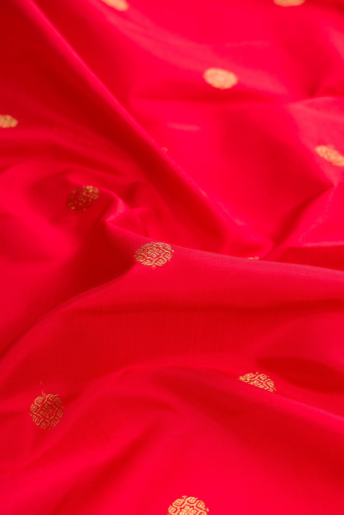 Close up of Red Dual Tone Kanjivaram Silk Saree with Zari Butta on the body and Zari Border.  displaying folds