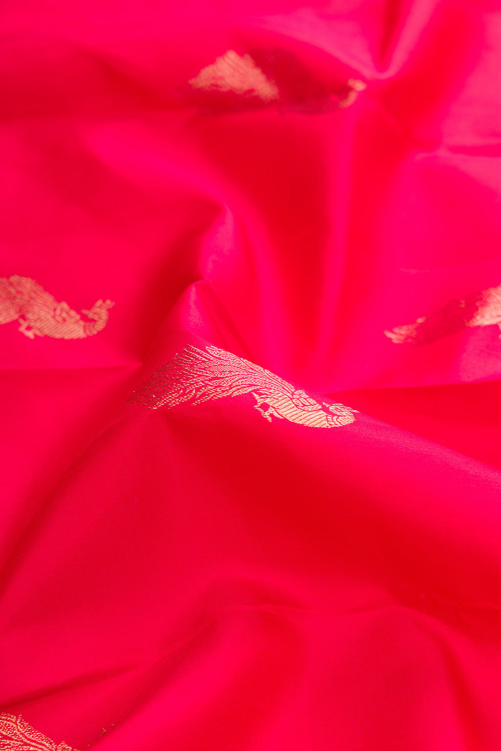Close up of Red Dual Tone Kanjivaram Silk Saree with Zari Butta on the body and Zari Border.  displaying folds