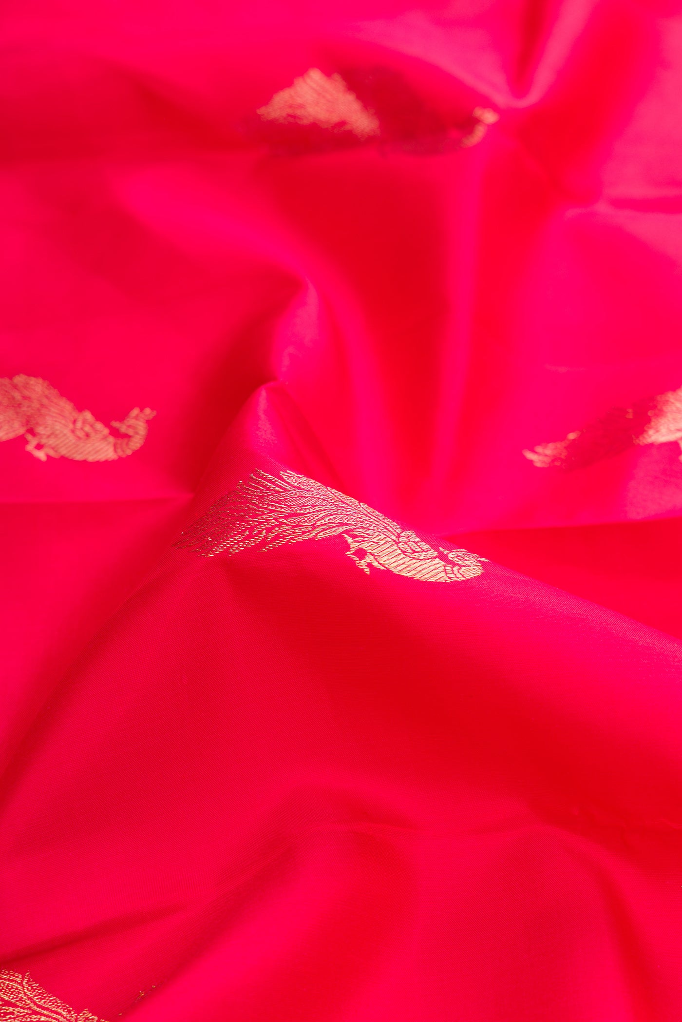 Close up of Red Dual Tone Kanjivaram Silk Saree with Zari Butta on the body and Zari Border.  displaying folds