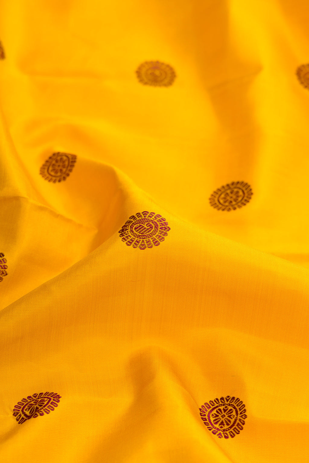 Close up of Mustard Dual Tone Kanjivaram Silk Saree with Thread Butta on the body and Fancy Border.  displaying folds