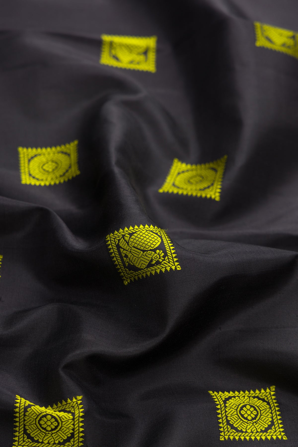 Close up of Black Dual Tone Kanjivaram Silk Saree with Thread Butta on the body and Fancy Border.  displaying folds
