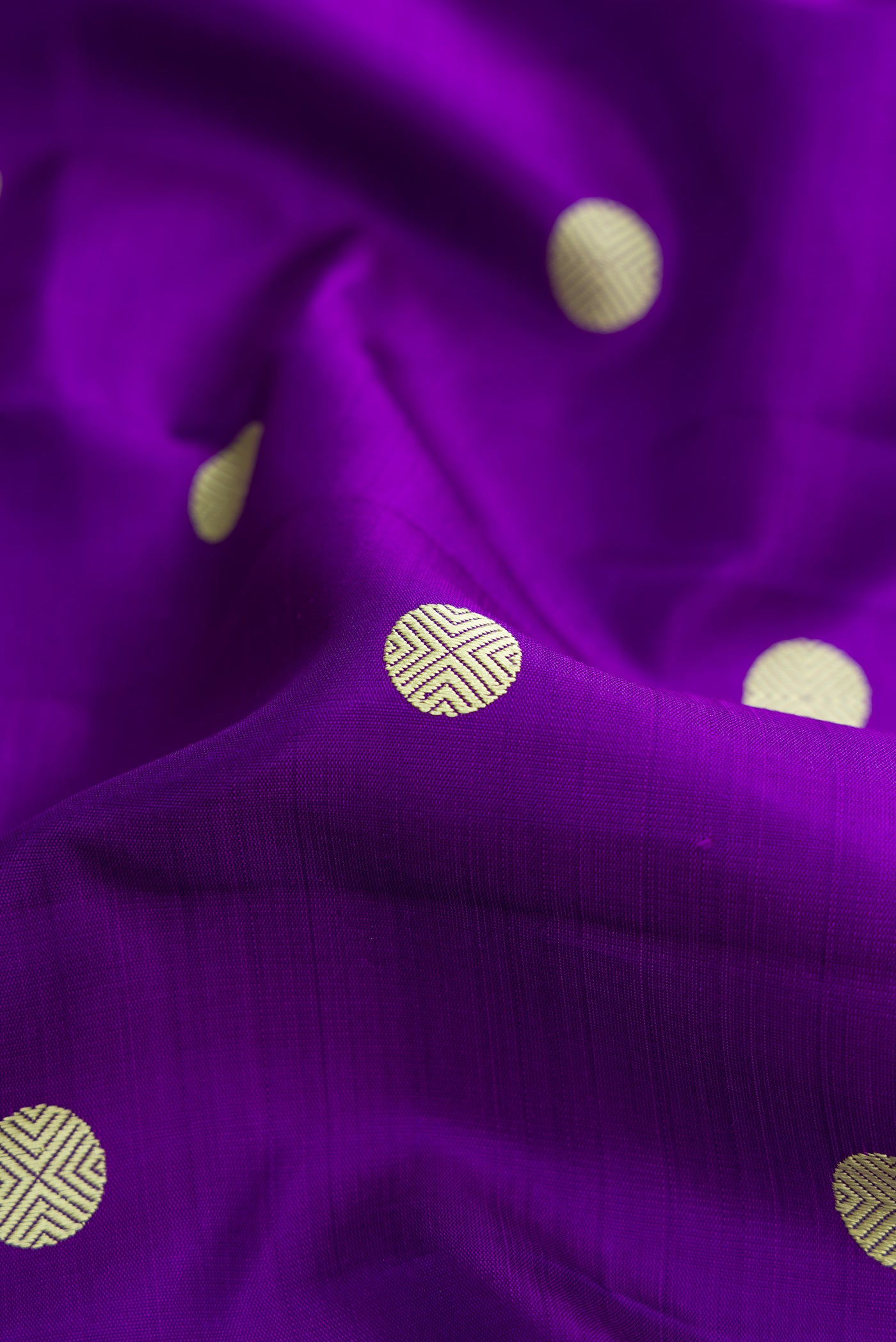 Close up of Violet Dual Tone Kanjivaram Silk Saree with Thread Butta on the body and Zari And Thread Border.  displaying folds