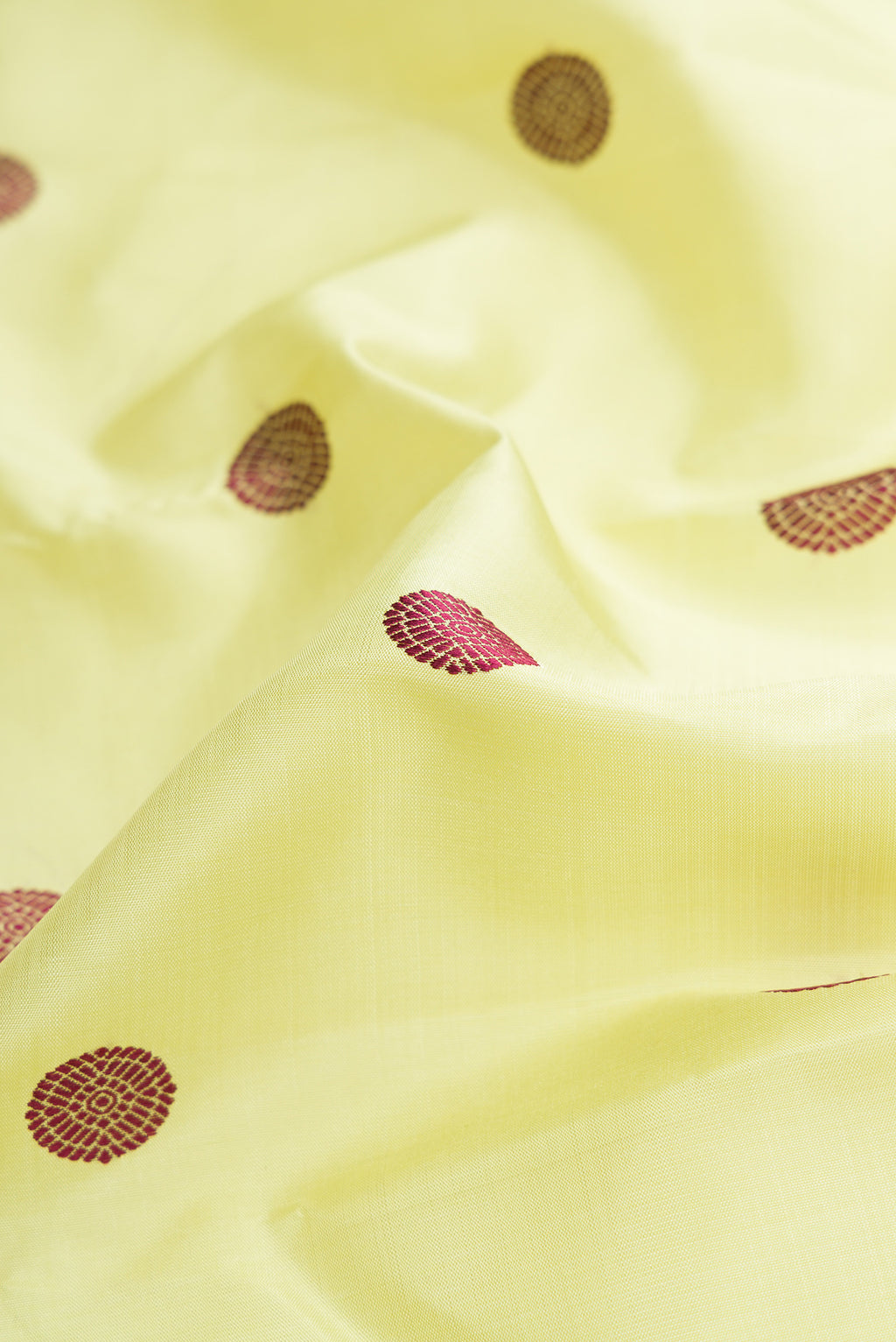 Close up of Pure Silk Pure Zari Parrot Green Dual Tone Kanjivaram Saree with Thread Butta on the body and Zari Border.  displaying folds