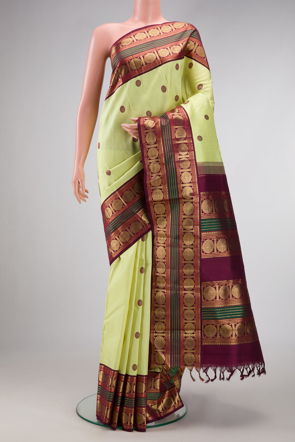 Pure Silk Pure Zari Parrot Green Dual Tone Kanjivaram Saree with Thread Butta on the body and Zari Border.  displayed on a mannequin
