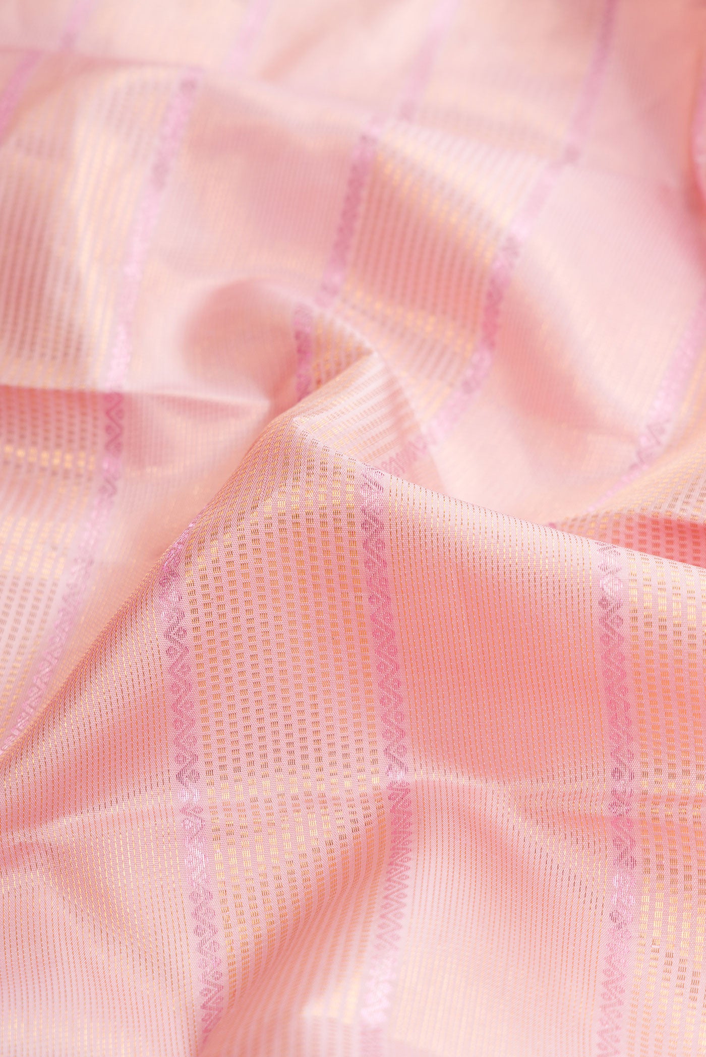 Close up of Pink Dual Tone Kanchipuram Silk Saree with Checked design on the body and Zari Border.  displaying folds