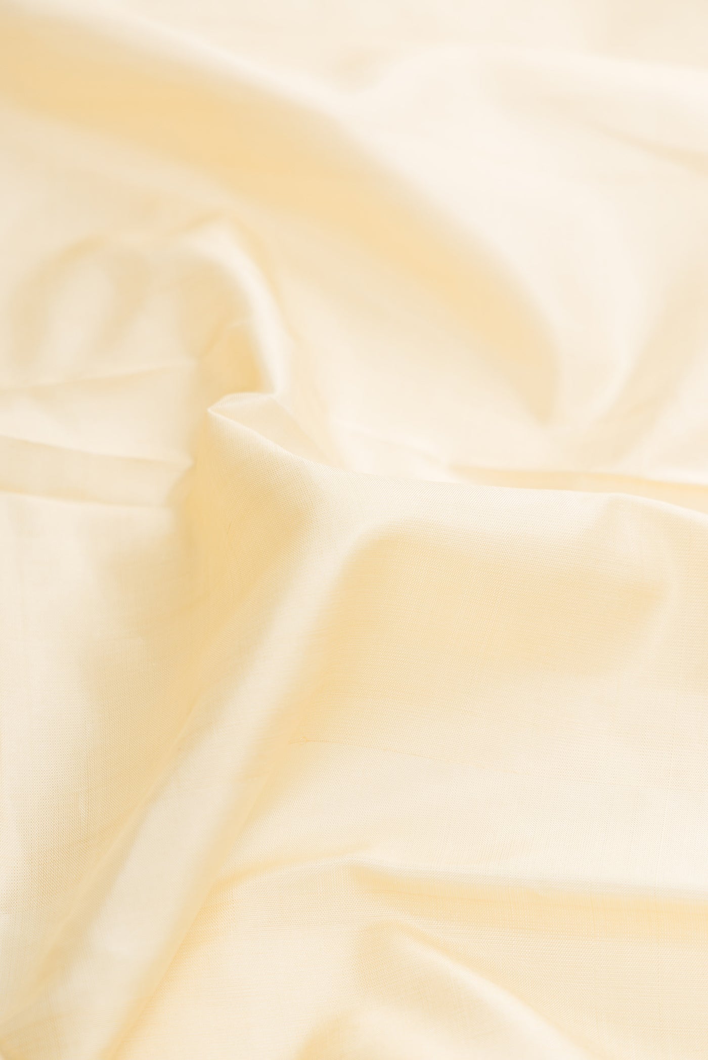 Close up of Off White Dual Tone Kanjivaram Silk Saree with Plain Body and Zari Border.  displaying folds
