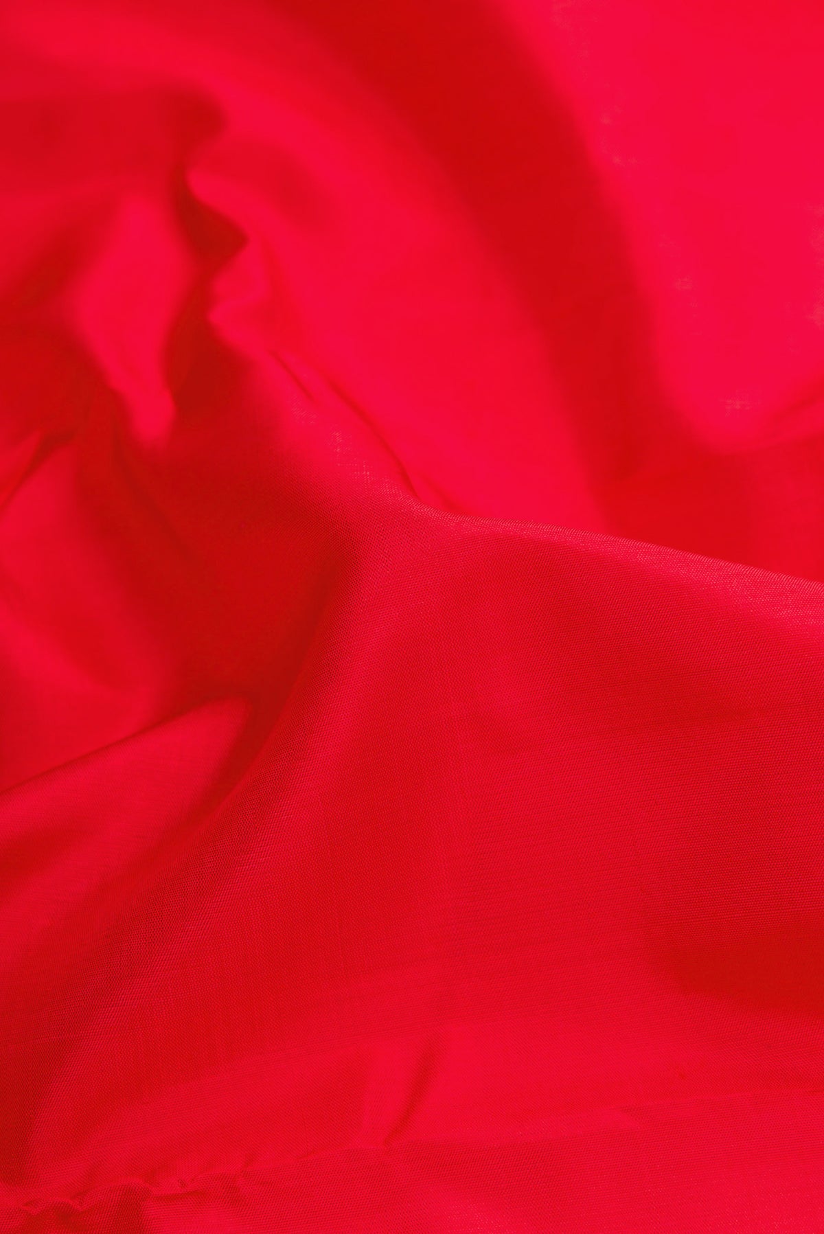 Close up of Red Dual Tone Kanjivaram Silk Saree with Plain Body and Zari Border.  displaying folds