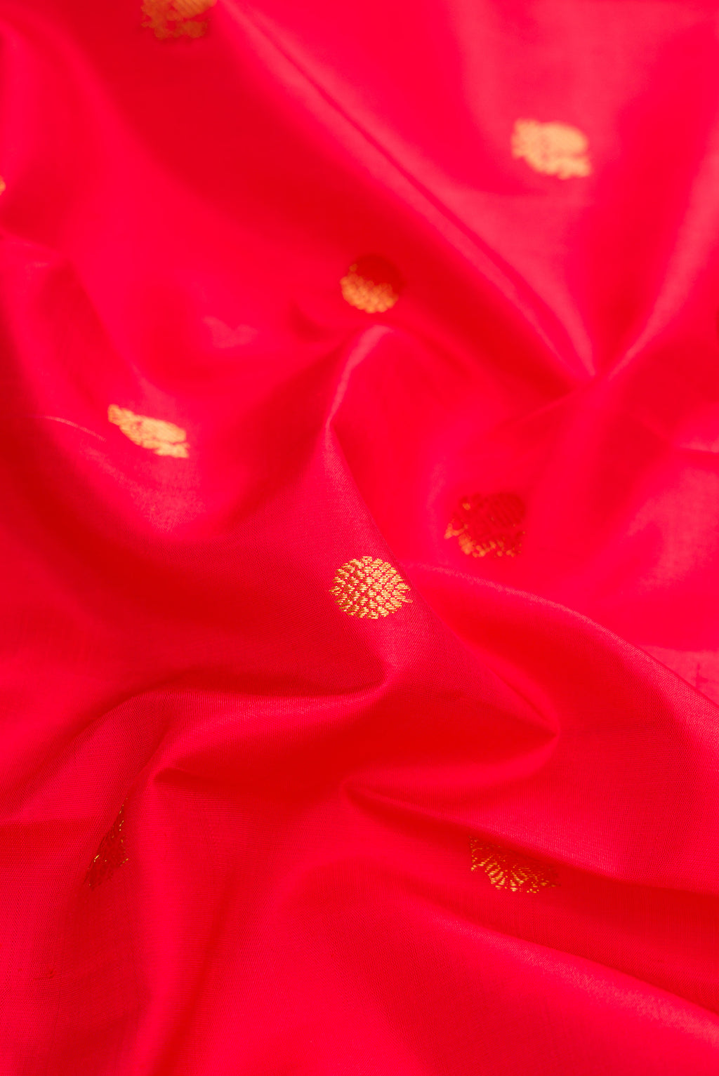 Close up of Red Dual Tone Kanjivaram Silk Saree with Zari Butta on the body and Zari Border.  displaying folds