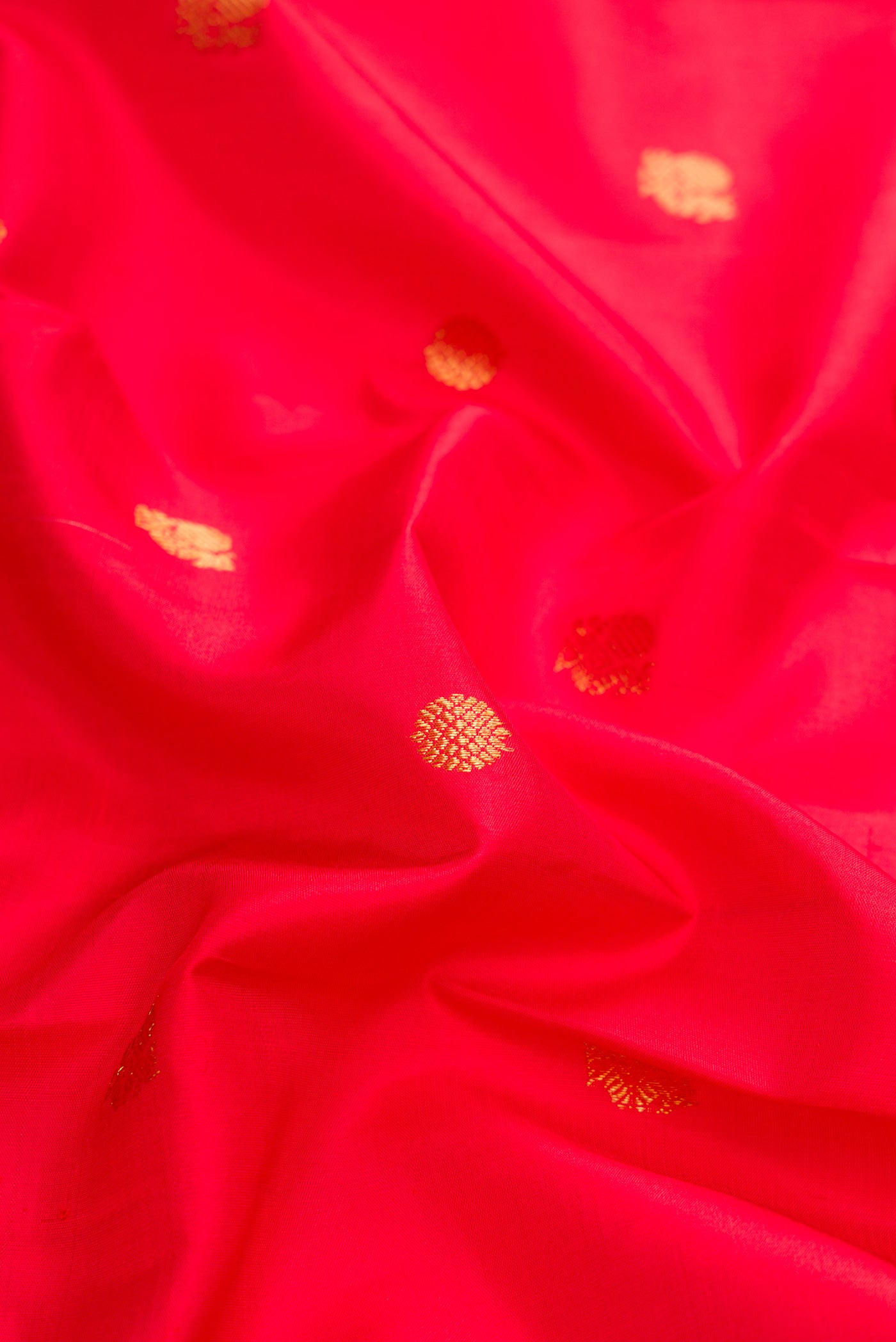 Close up of Red Dual Tone Kanjivaram Silk Saree with Zari Butta on the body and Zari Border.  displaying folds