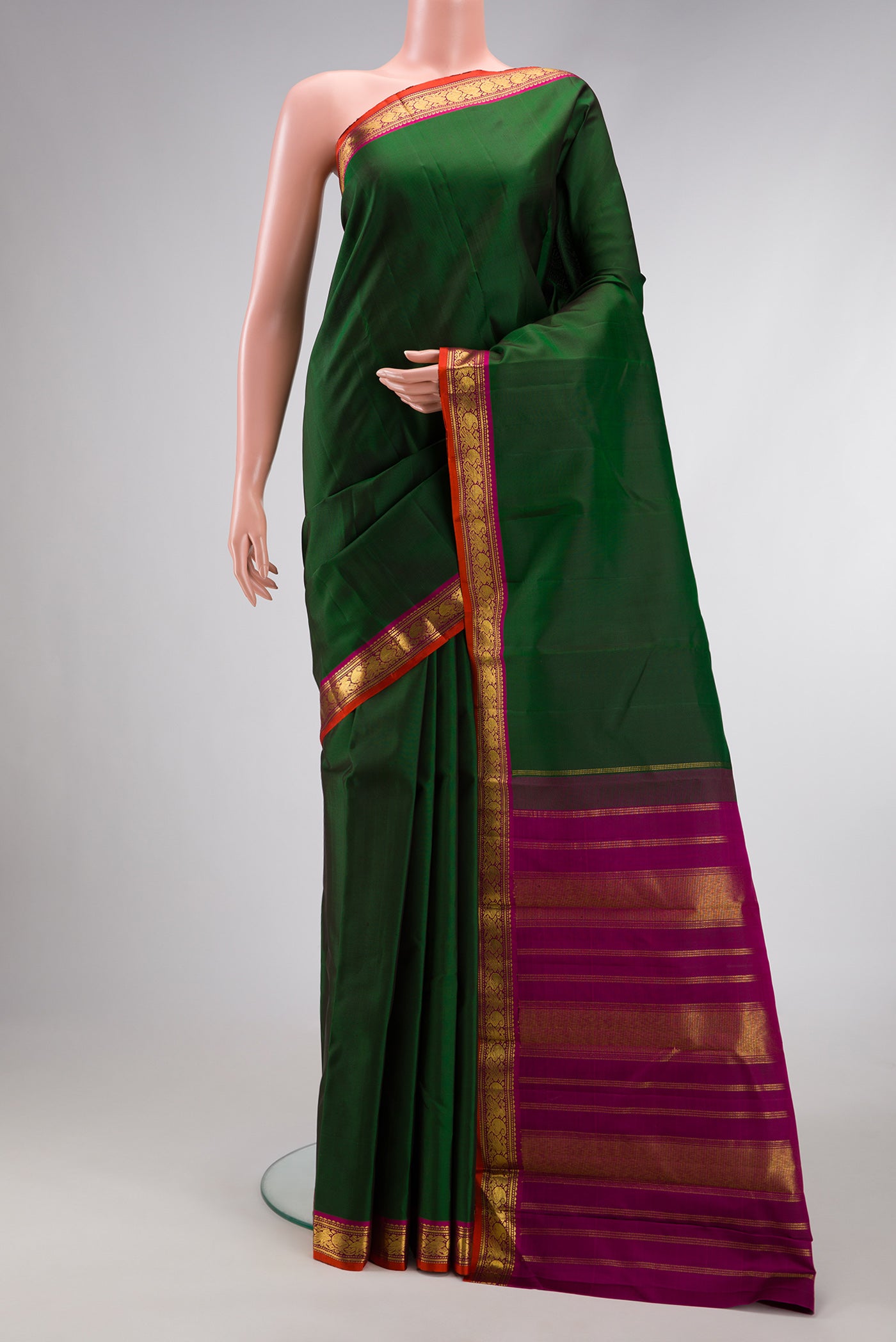 Bottle Green Dual Tone Kanjivaram Silk Saree with Plain Body and Zari Border.  displayed on a mannequin