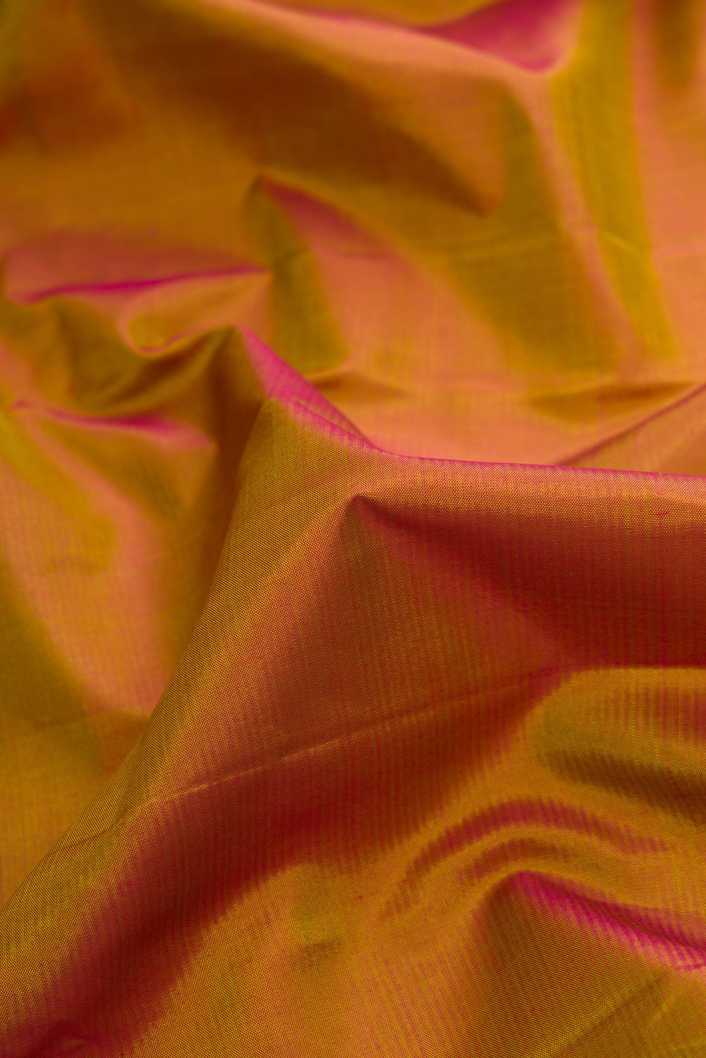 Close up of Pure Silk Pure Zari Mehandi Green Dual Tone Kanjivaram Saree with Plain Body and Zari Border.  displaying folds