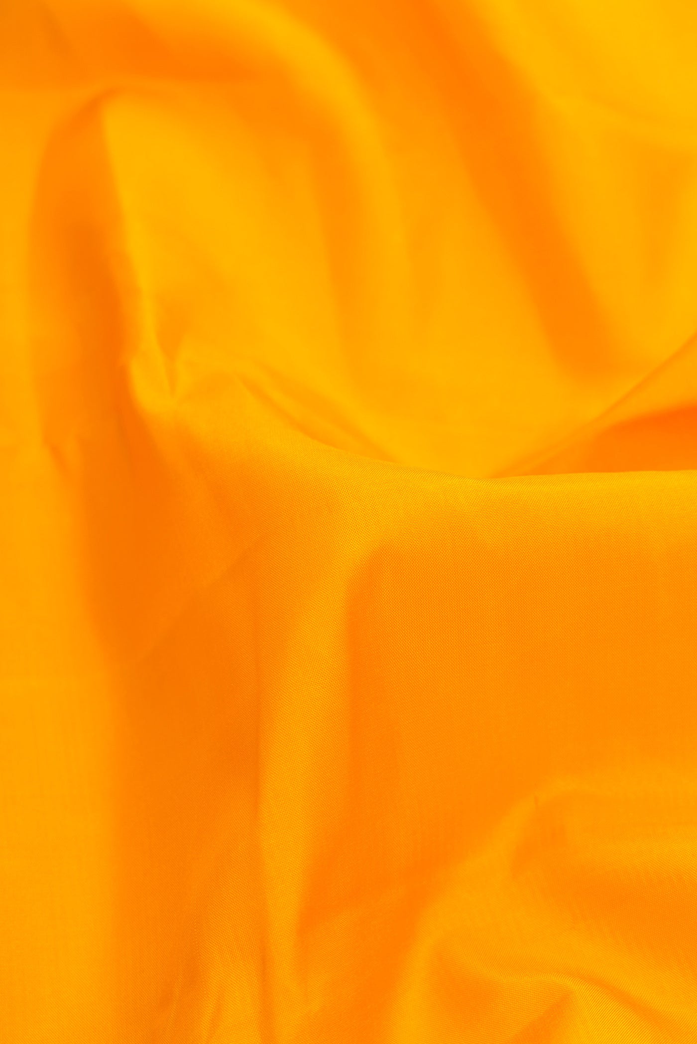 Close up of Yellow Dual Tone Kanjivaram Silk Saree with Plain Body and Zari Border.  displaying folds
