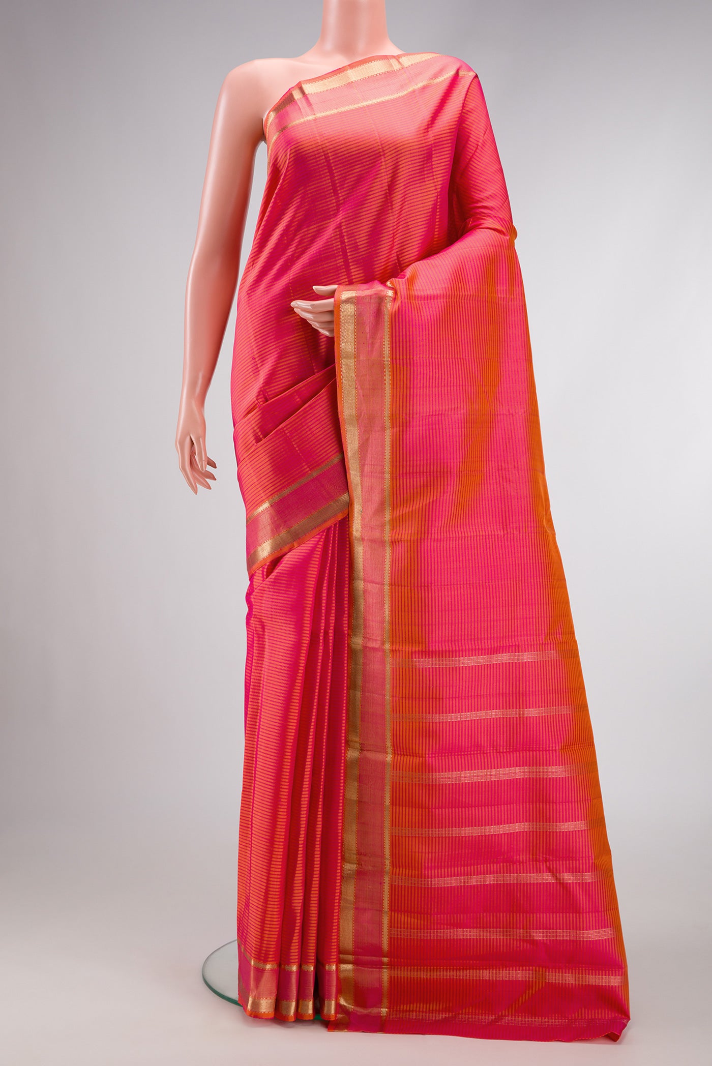 Coral Dual Tone Kanjivaram Silk Saree with Stripes on the body and Zari Border.  displayed on a mannequin