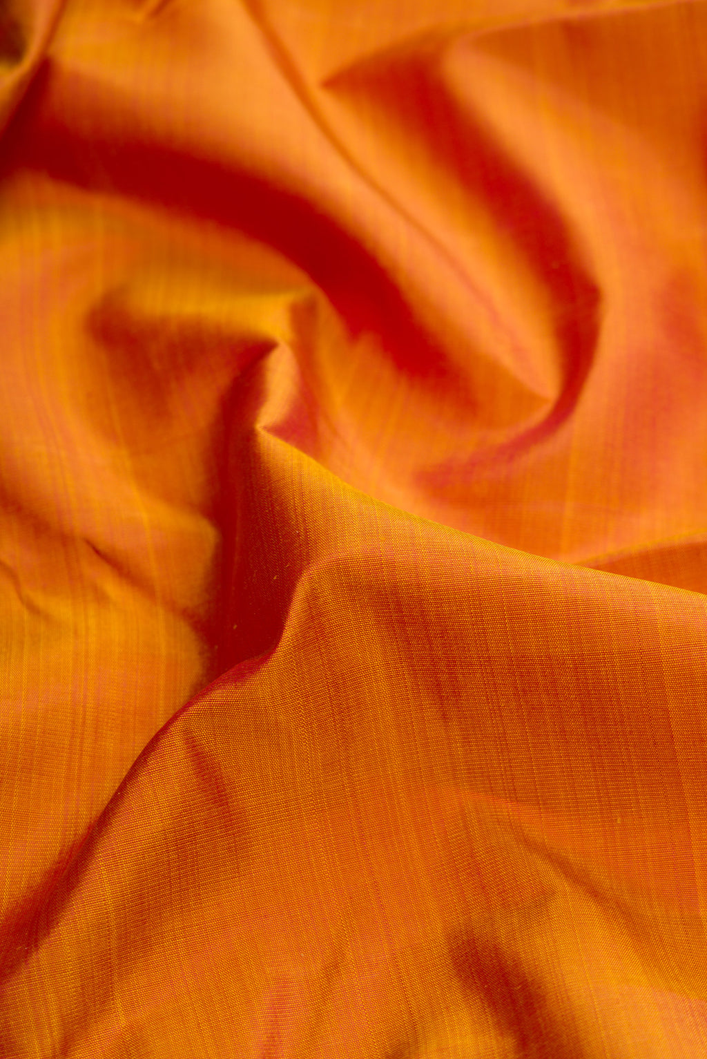 Close up of Mustard Dual Tone Kanjivaram Silk Saree with Plain Body and Fancy Border.  displaying folds