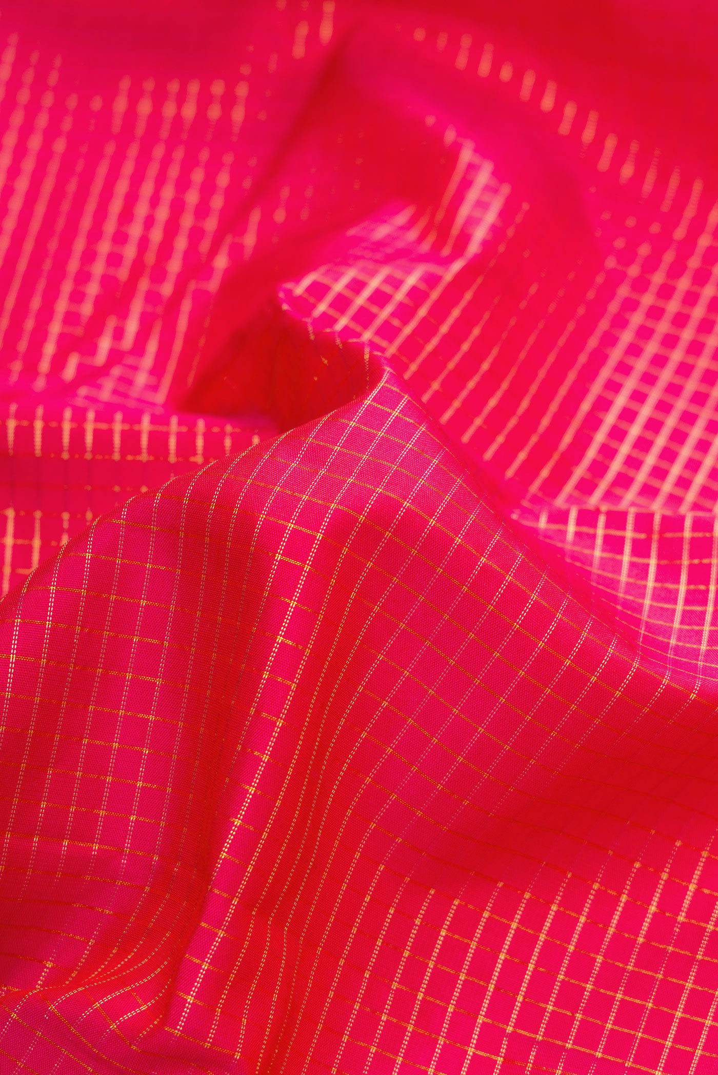 Close up of Pink Dual Tone Kanjivaram Silk Saree with Checked design on the body and Zari Border.  displaying folds