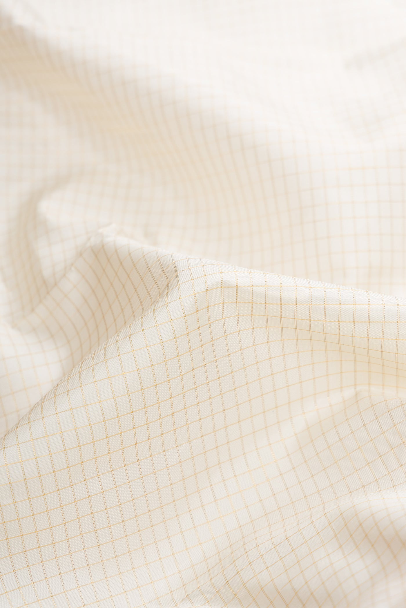 Close up of Off White Dual Tone Kanjivaram Silk Saree with Checked design on the body and Zari Border.  displaying folds