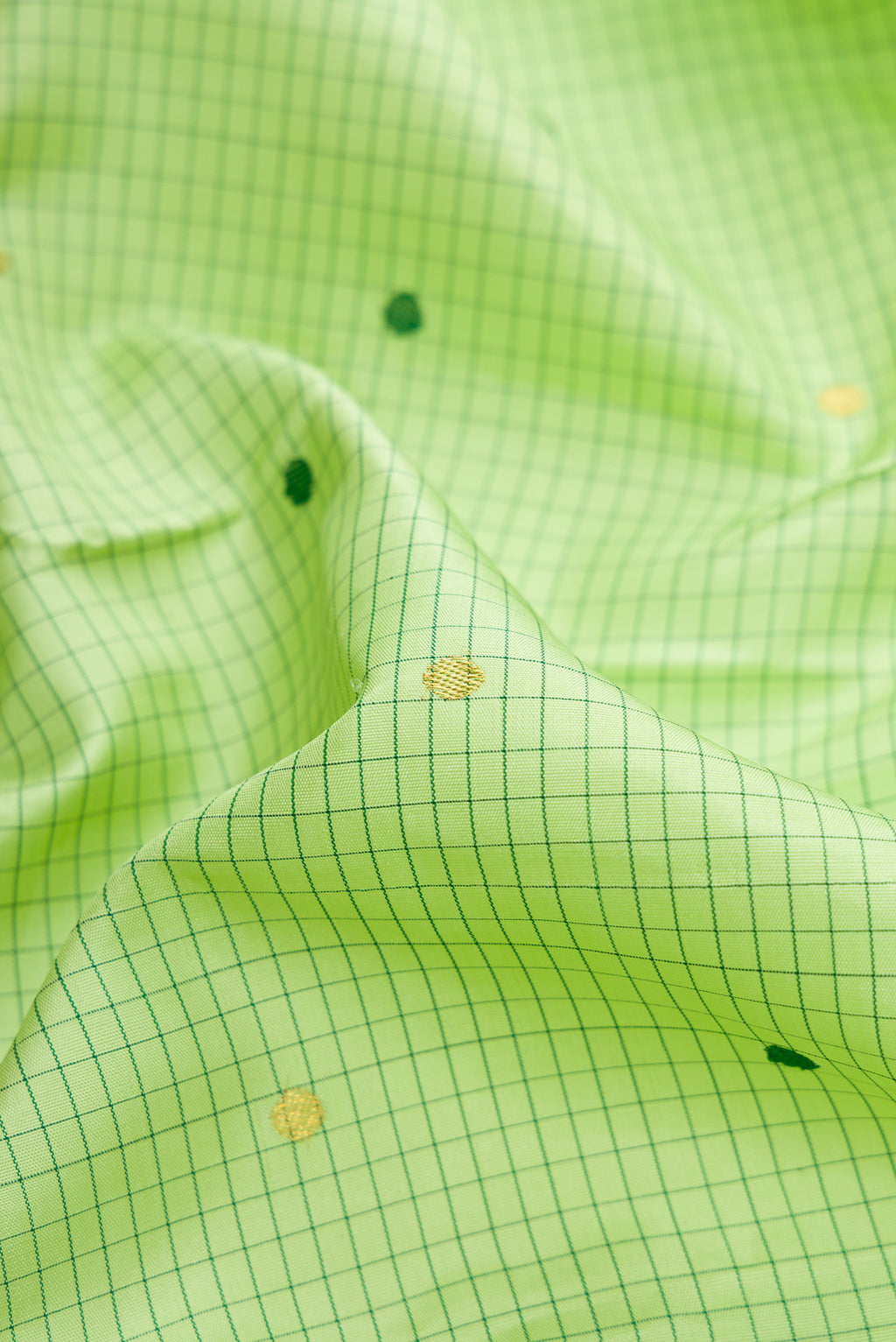 Close up of Parrot Green Dual Tone Kanjivaram Silk Saree with Checked design on the body and Zari And Thread Border.  displaying folds