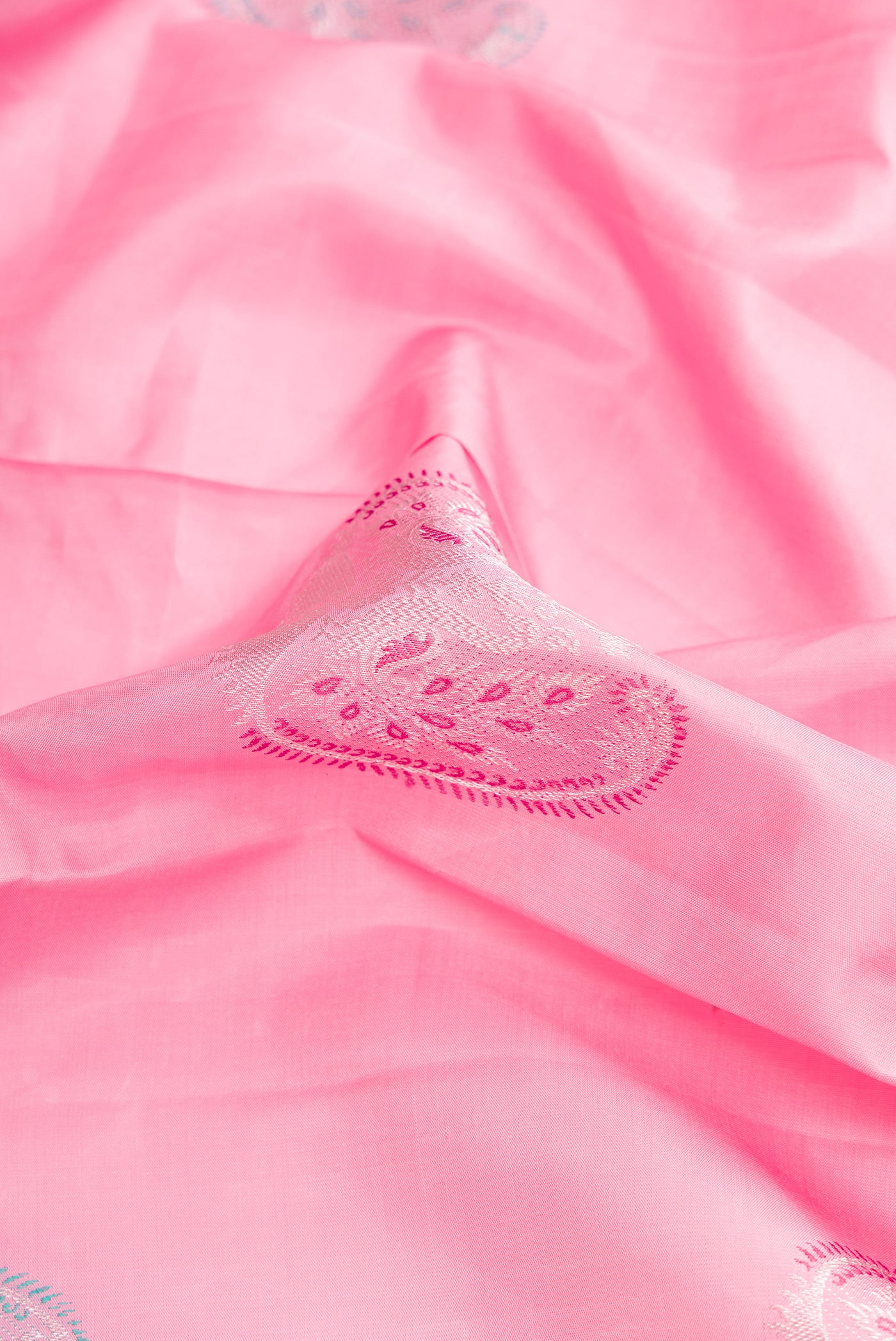 Close up of Pink Dual Tone Kanjivaram Silk Saree with Zari And Thread Butta on the body and Without Border.  displaying folds