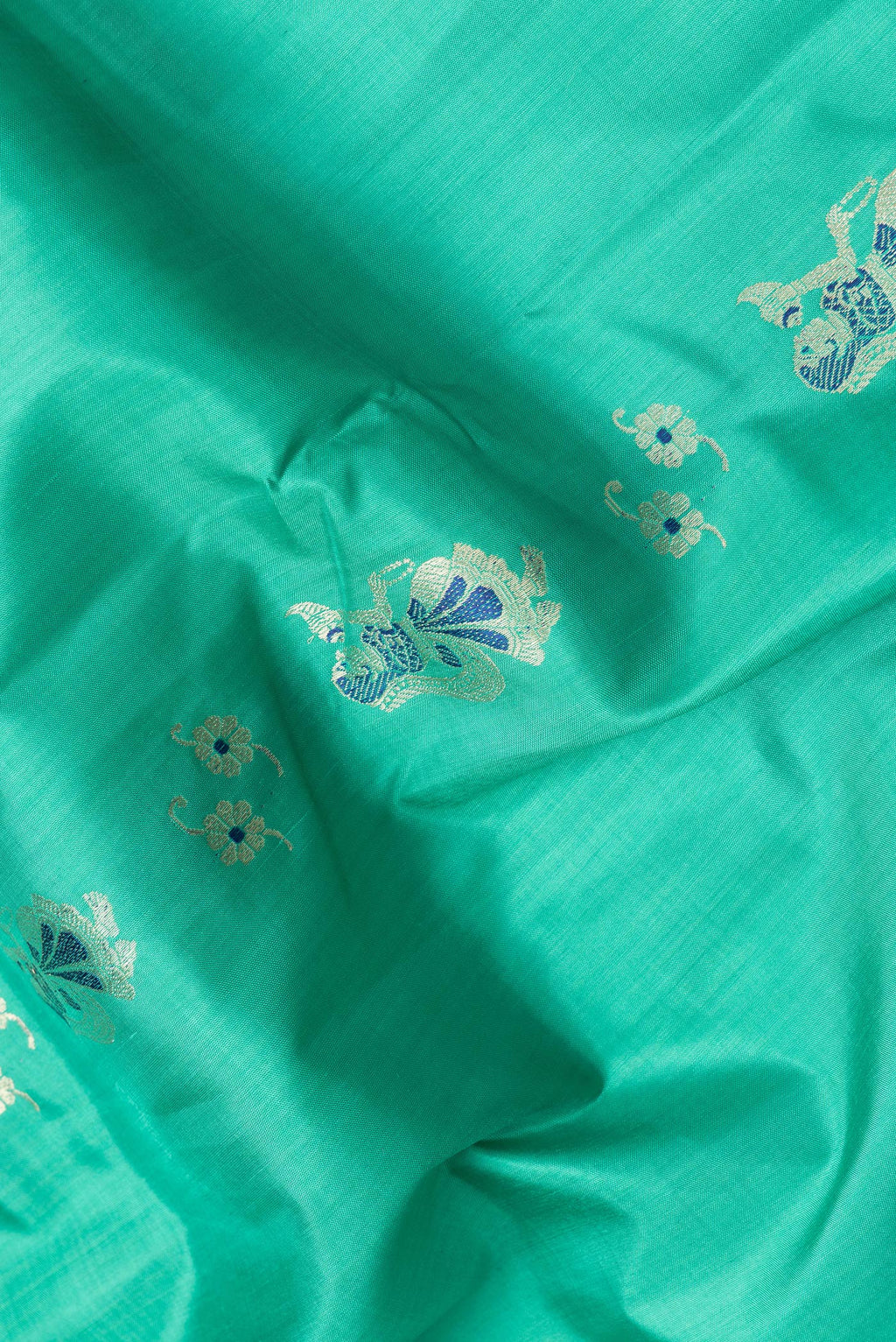 Close up of Sea Green Dual Tone Baluchari Silk Saree with Zari And Thread Butta on the body and Fancy Border.  displaying folds