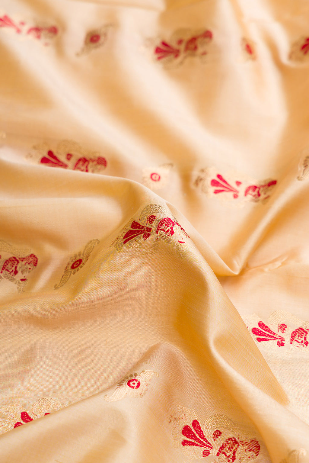 Close up of Beige Dual Tone Baluchari Silk Saree with Zari And Thread Butta on the body and Zari Border.  displaying folds