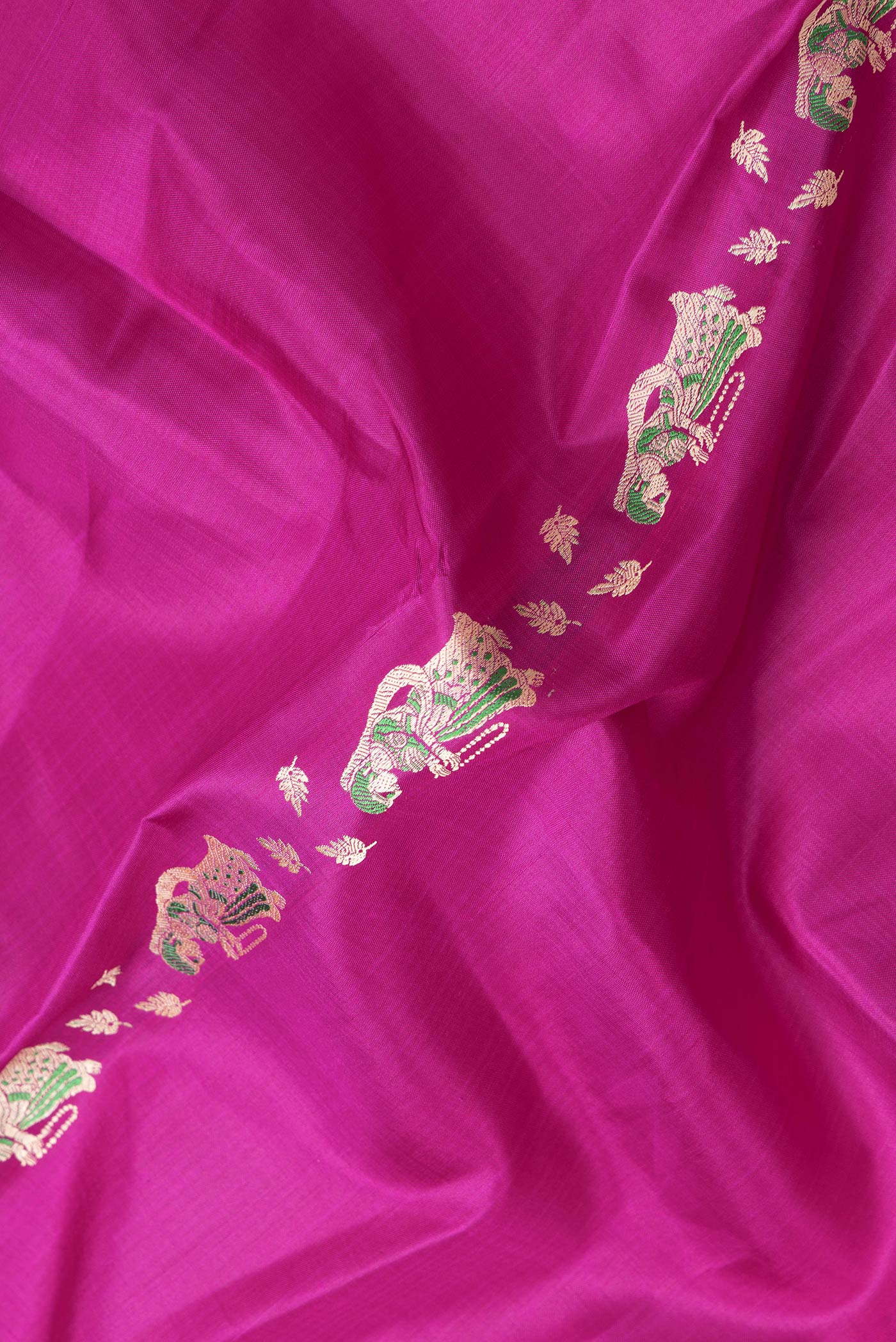 Close up of Magenta Dual Tone Baluchari Silk Saree with Thread Butta on the body and Fancy Border.  displaying folds