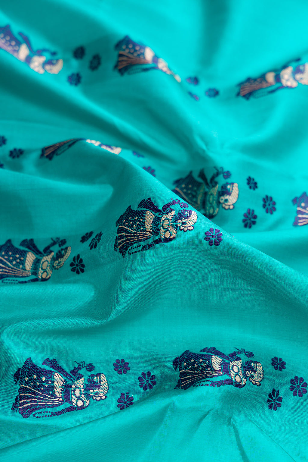 Close up of Sky Blue Dual Tone Baluchari Silk Saree with Thread Butta on the body and Thread Border.  displaying folds