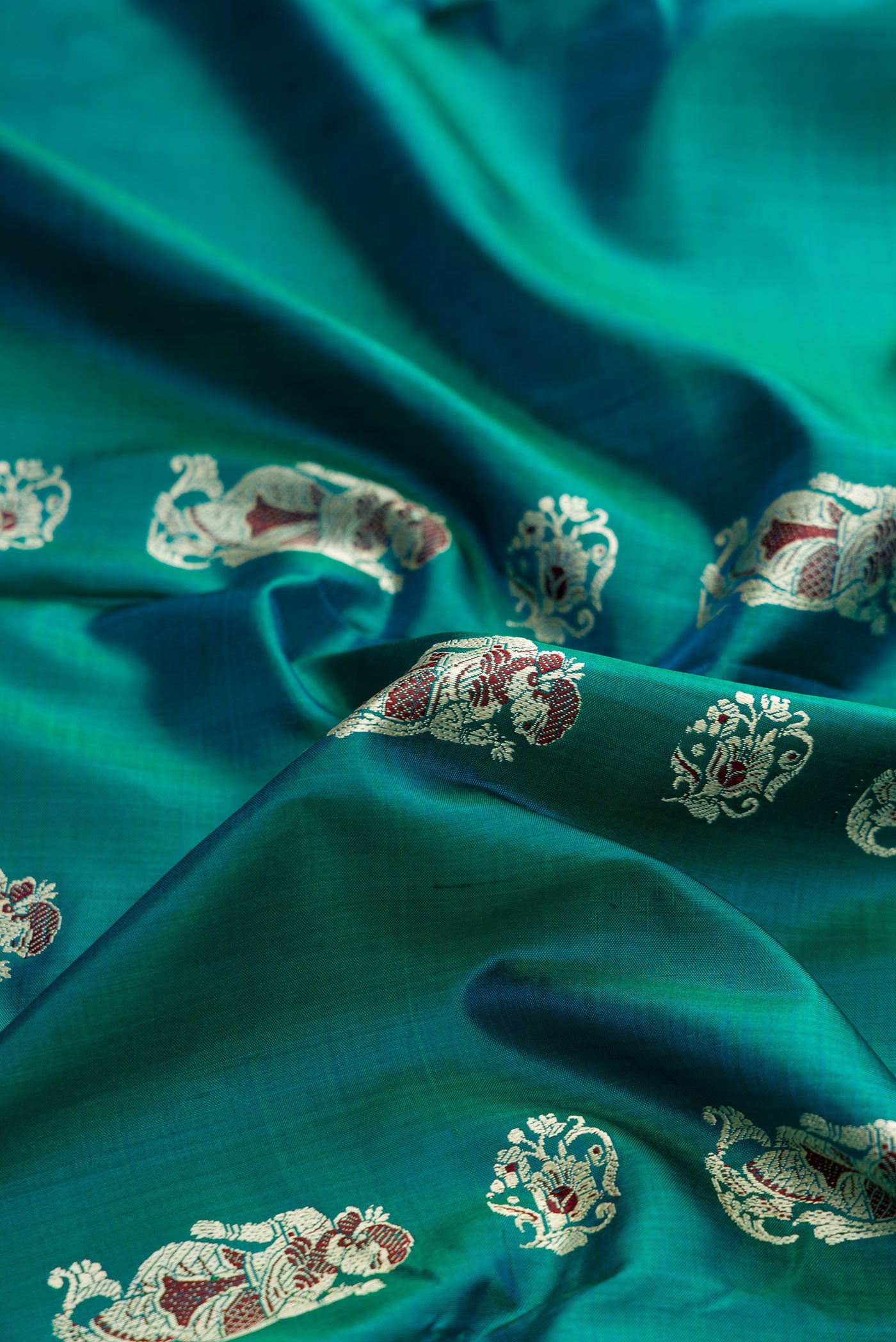 Close up of Green Dual Tone Baluchari Silk Saree with Thread Butta on the body and Thread Border.  displaying folds