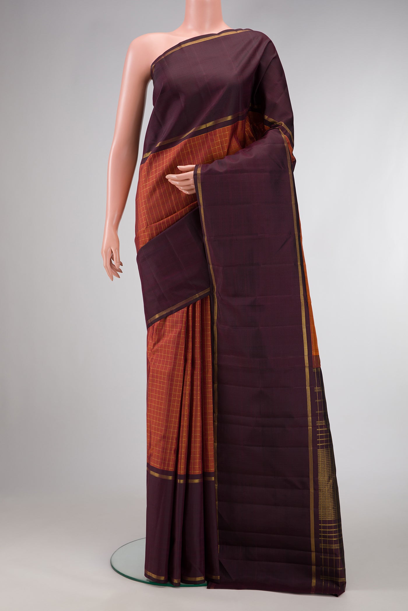 Brick Orange Dual Tone Kanjivaram Silk Saree with Checked design on the body and Zari Border.  displayed on a mannequin