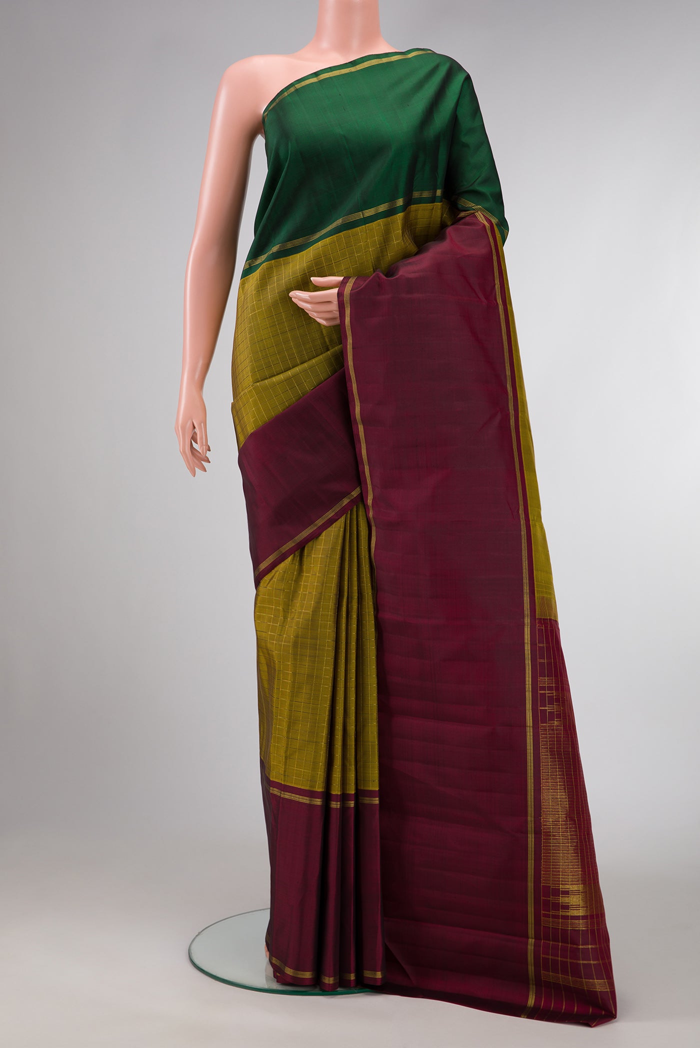 Mehandi Green Dual Tone Kanjivaram Silk Saree with Checked design on the body and Ganga Jamuna Border.  displayed on a mannequin