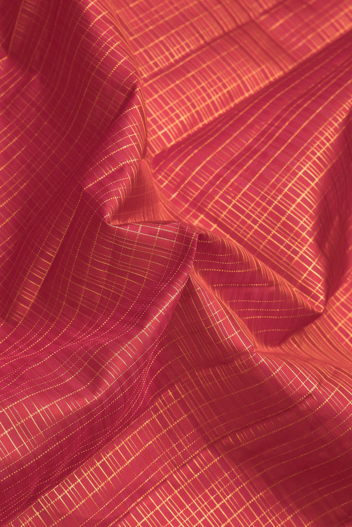 Close up of Dark Pink Dual Tone Kanchipuram Silk Saree with Checked design on the body and Zari Border.  displaying folds