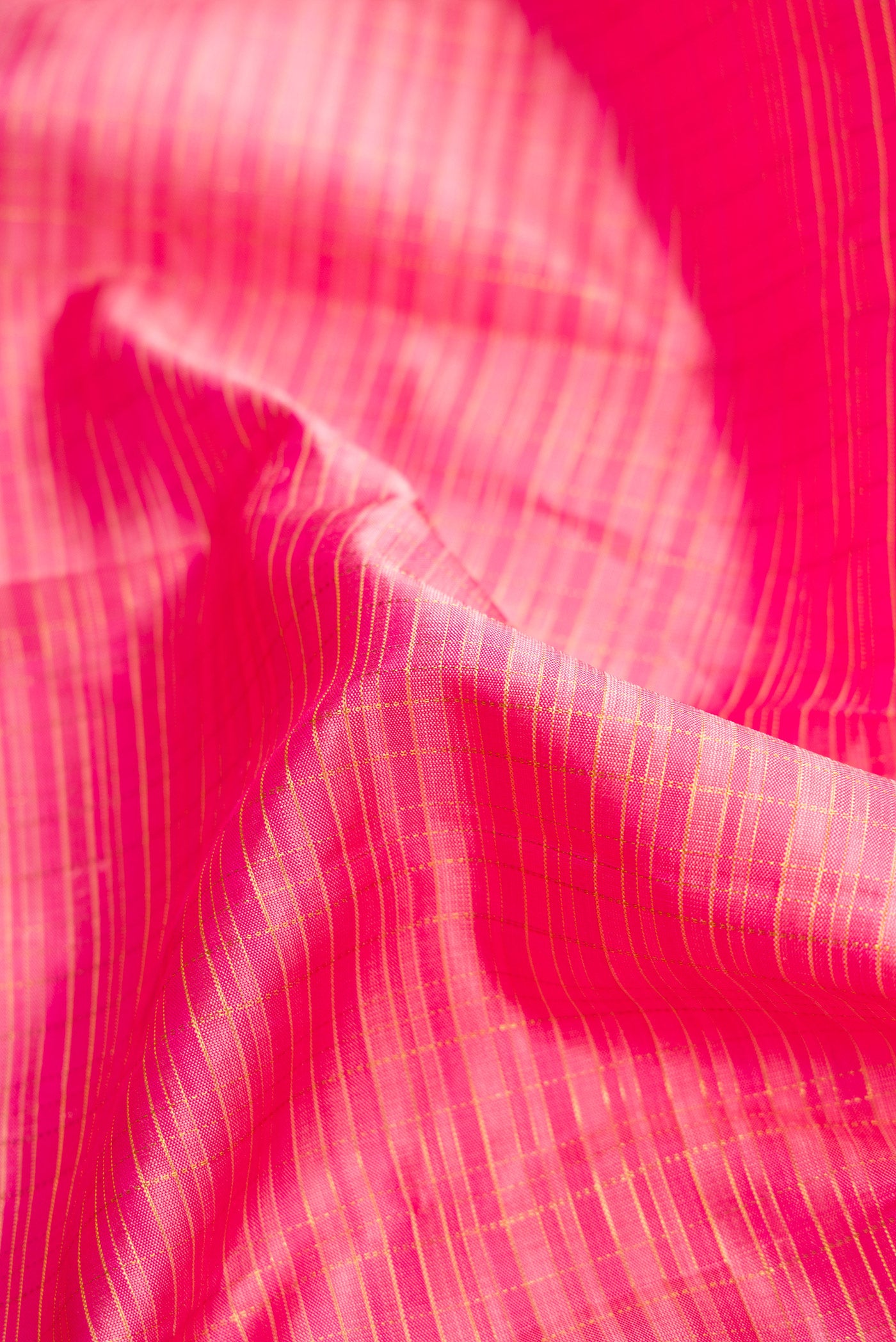 Close up of Pink Dual Tone Kanjivaram Silk Saree with Stripes on the body and Zari Border.  displaying folds