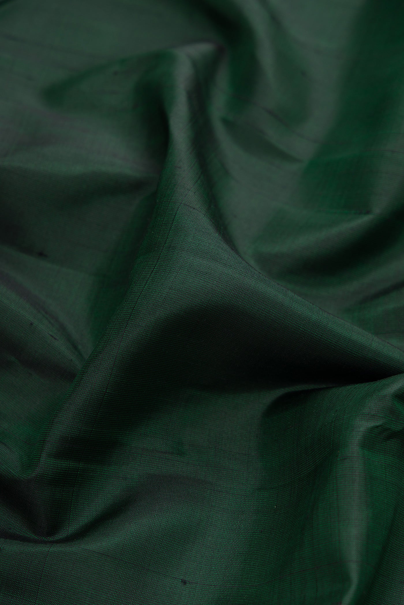 Close up of Bottle Green Dual Tone Kanjivaram Silk Saree with Plain Body and Zari Border.  displaying folds