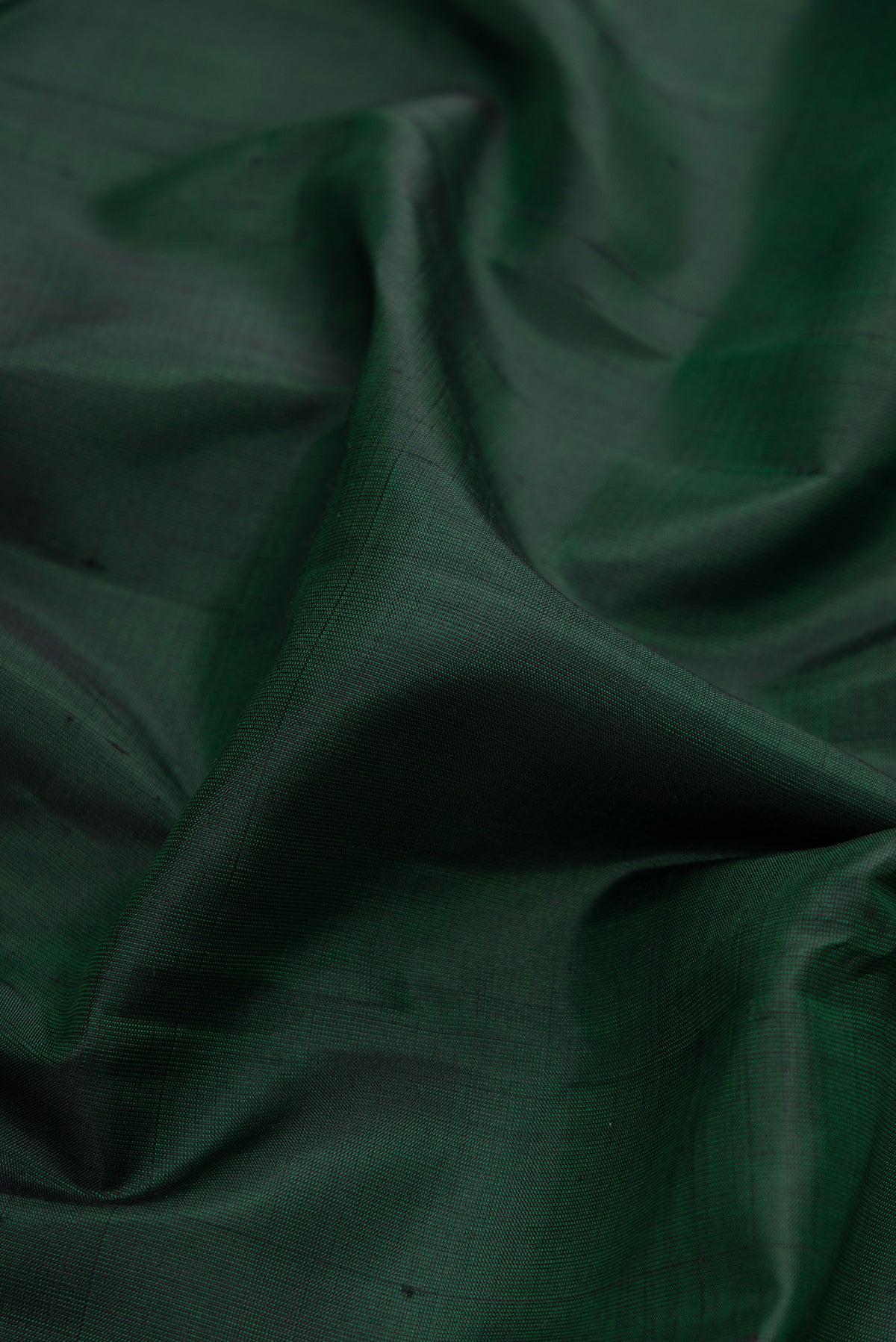 Close up of Bottle Green Dual Tone Kanjivaram Silk Saree with Plain Body and Zari Border.  displaying folds