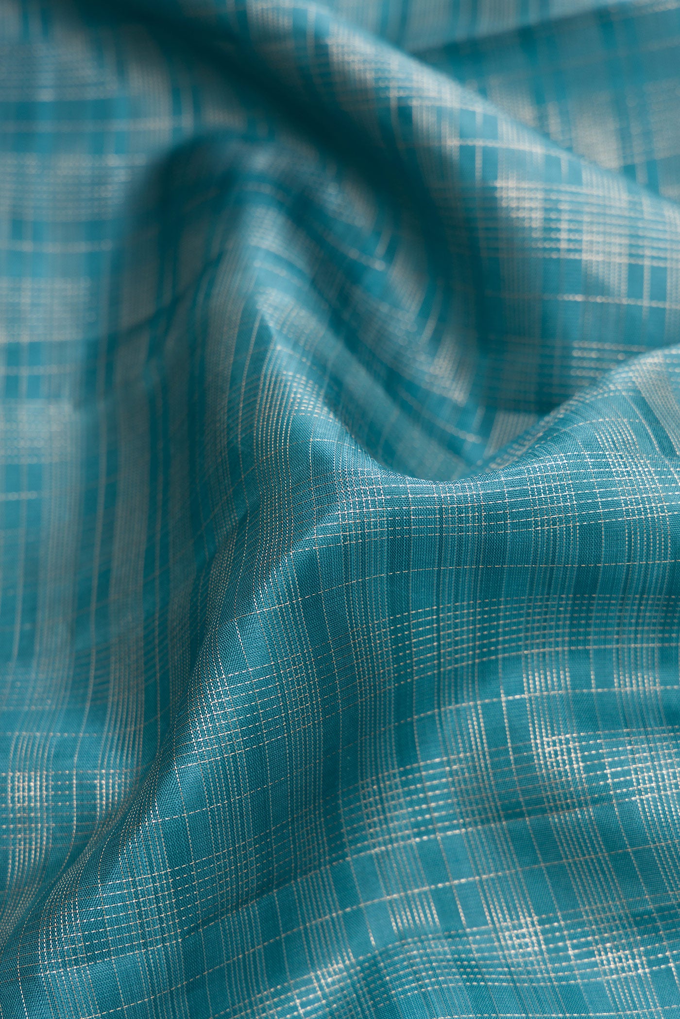 Close up of Maya Blue Dual Tone Kanjivaram Silk Saree with Checked design on the body and Zari Border.  displaying folds