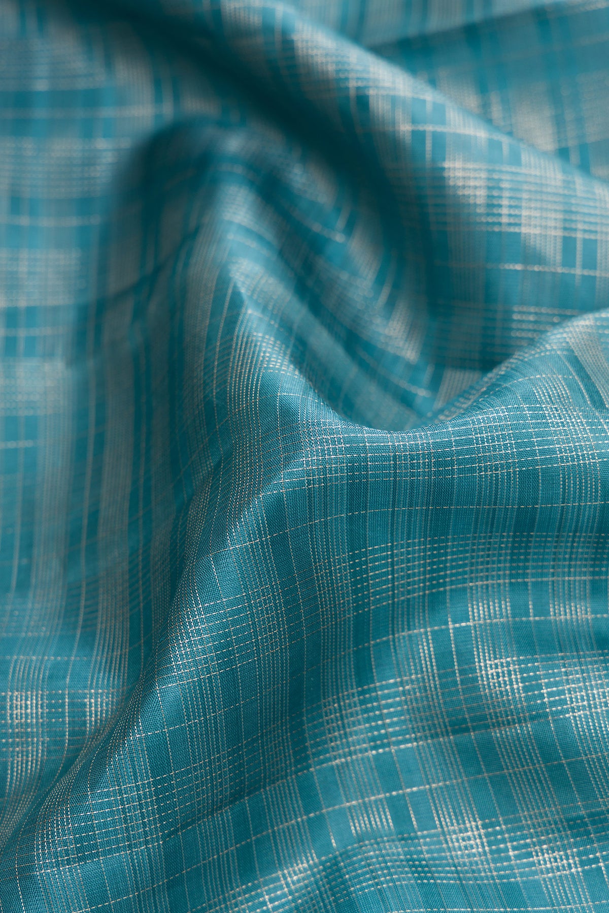 Close up of Maya Blue Dual Tone Kanjivaram Silk Saree with Checked design on the body and Zari Border.  displaying folds