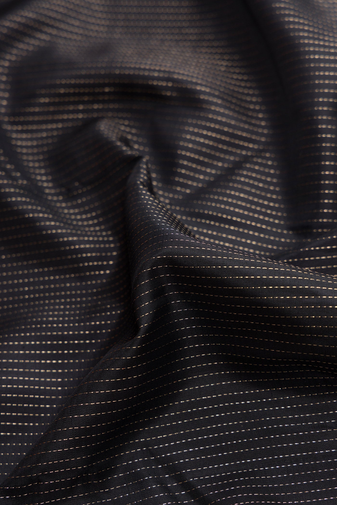 Close up of Black Dual Tone Kanjivaram Silk Saree with Stripes on the body and Without Border.  displaying folds