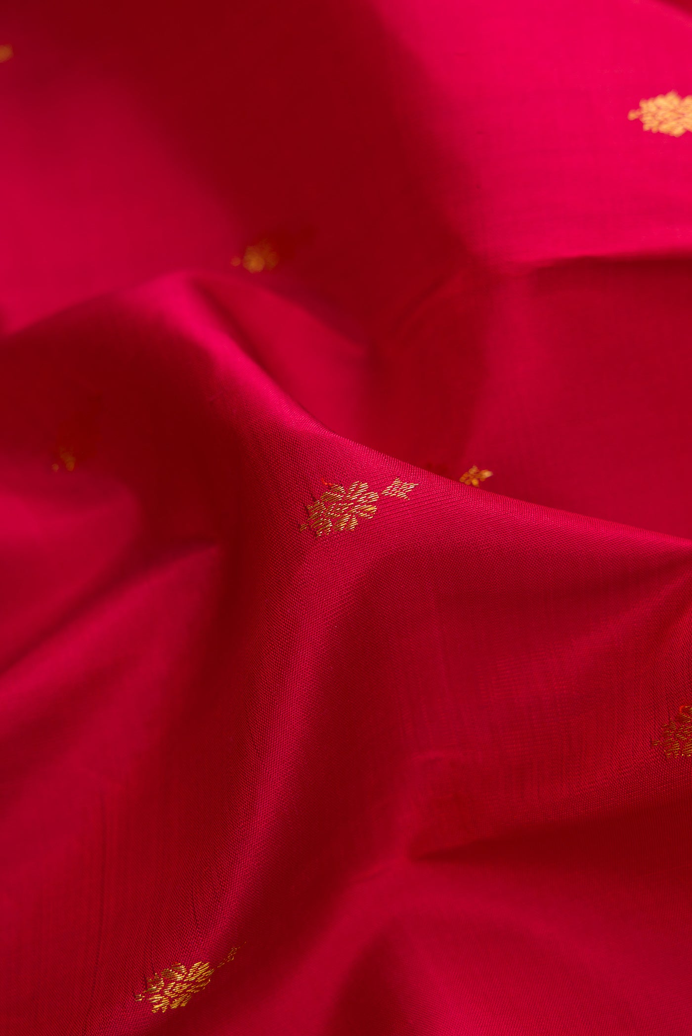 Close up of Red Dual Tone Kanjivaram Silk Saree with Zari Butta on the body and Zari Border.  displaying folds