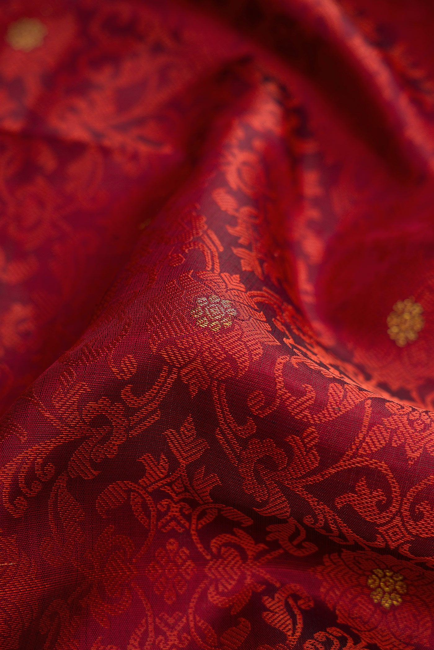Close up of Maroon Dual Tone Kanchipuram Silk Saree with Jacquard With Zari Butta on the body and Zari Border.  displaying folds